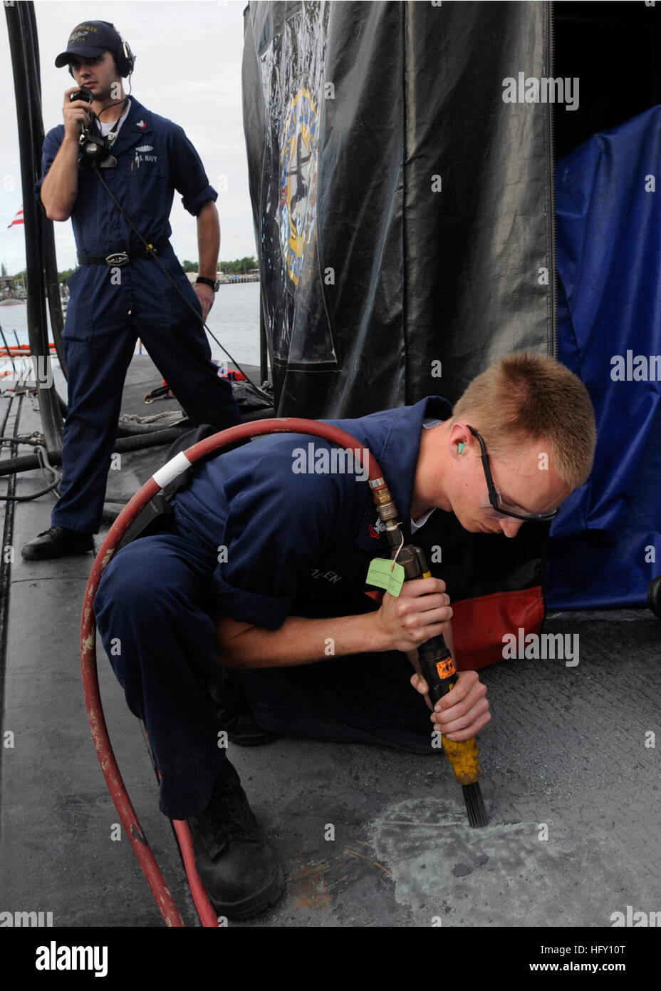 100127-N-3560G-001  PEARL HARBOR, Hawaii (Jan. 27, 2010) Machinist Mate 2nd Class Allan Patrick uses a pneumatic needle gun to perform maintenance on the outer deck of the Los Angeles-class attack submarine USS Louisville (SSN 724) during a pre-deployment upkeep period. Louisville is one of the most advanced attack submarines in the fleet. (U.S. Navy photo by Mass Communication Specialist 2nd Class Ronald Gutridge/Released) US Navy 100127-N-3560G-001 Sailor performs maintenance aboard USS Louisville Stock Photo