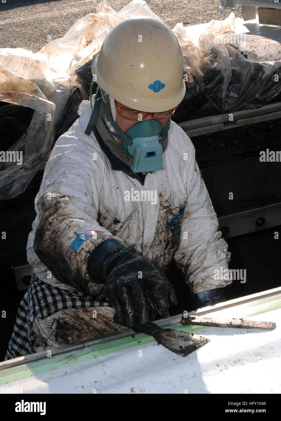 A Japanese shipyard worker performs maintenance on one of USS George Washington's four aircraft catapults. Japanese workers play a critical role in maintaining and upgrading equipment while the Navy's only permanently forward-deployed aircraft carrier is in port. 2010 is the 50th anniversary of the treaty of mutual cooperation and security between Japan and the United States. (Photo by: Petty Officer 2nd Class John J. Mike) USS George Washington DVIDS248282 Stock Photo
