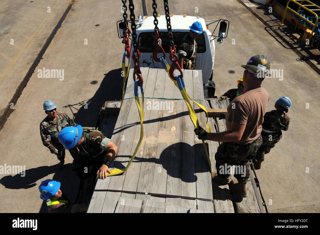 100218-N-6436W-032 GUANTANAMO BAY, Cuba (Feb. 18, 2010) Sailors assigned to Navy Reserve Naval Cargo Handling Battalion 13 attach lumber to a crane to be transported to Haiti. More than 180,000 board feet of lumber was sent to support Operation Unified Response. (U.S. Navy photo by Mass Communication Specialist 1st Class Michael B. Watkins/Released) US Navy 100218-N-6436W-032 Sailors assigned to Navy Reserve Naval Cargo Handling Battalion 13 attach lumber to a crane to be transported to Haiti Stock Photo