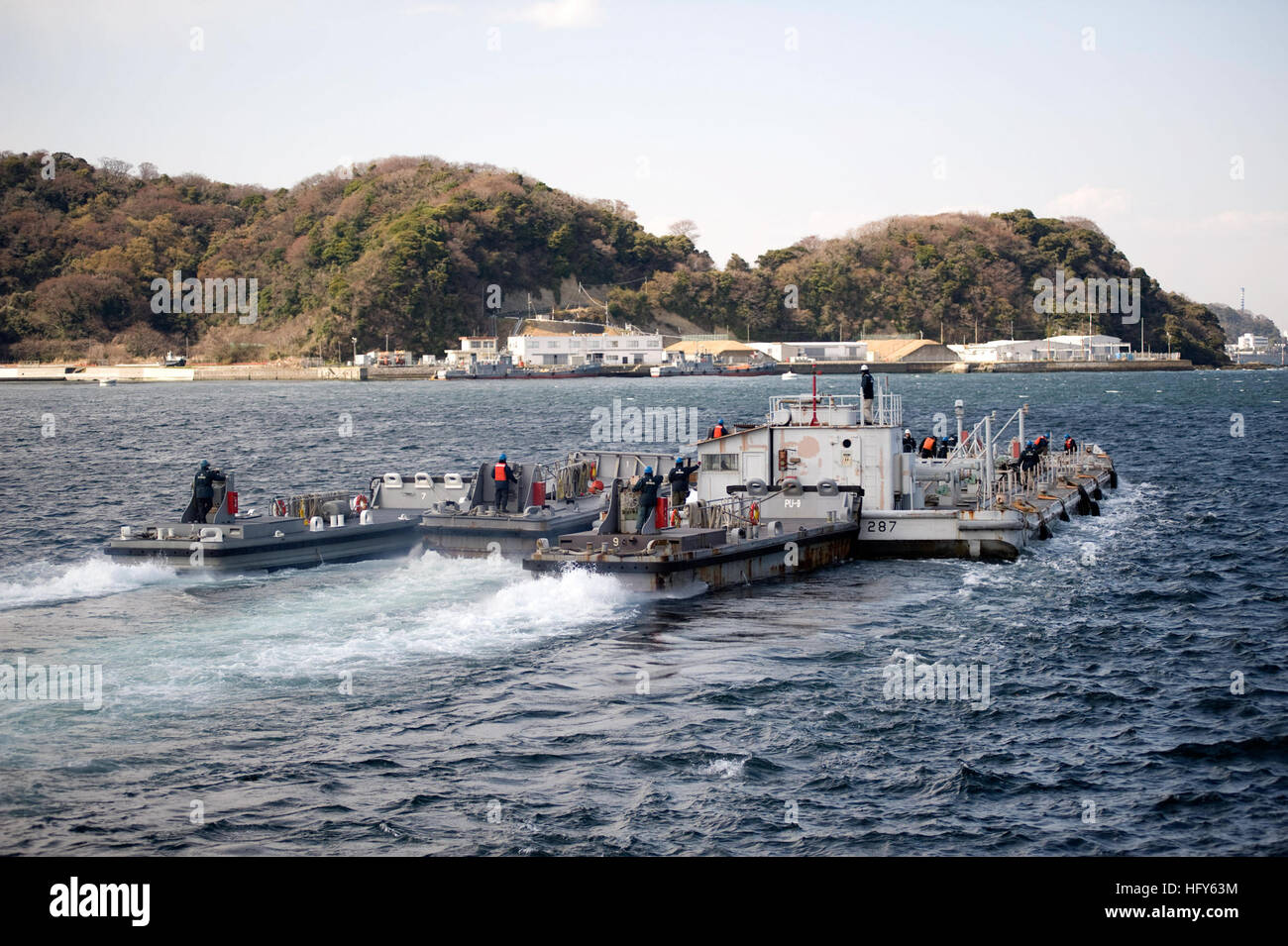 110326-N-UZ446-088 YOKOSUKA, Japan (March 26, 2011) U.S. Navy Barge YON-287, filled with 851,000 liters (225,000 gallons) of fresh water, departs Fleet Activities Yokosuka to support cooling efforts at the Fukushima Daiichi nuclear power plant. YON-287 is the second of two barges supplied by the U.S. Navy to the government of Japan to aid in the cooling efforts. The two barges supplied a total of 1.89 million liters (500,000 gallons) of fresh water. (U.S. Navy Photo by Mass Communication Specialist 2nd Class John Smolinski/Released) US Navy 110326-N-UZ446-088 Stock Photo