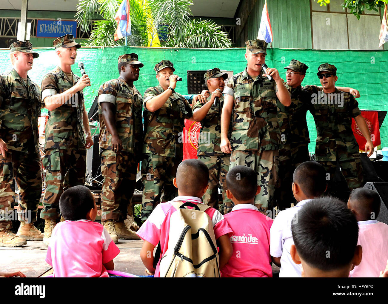 100514-N-8377A-329 RAYONG PROVINCE, Thailand (May 14, 2010) Seabees entertain Thai school children by singing the Seabee song during a building dedication for a civil engineering civic action project at Ban Klong Kam Primary School as part of Cooperation Afloat Readiness and Training (CARAT) Thailand 2010. CARAT 2010 is a series of exercises held annually to strengthen relationships and improve operational readiness throughout Southeast Asia. (U.S. Navy photo by Chief Mass Communication Specialist Michael Ard/Released) US Navy 100514-N-8377A-329 Seabees entertain Thai school children by singin Stock Photo