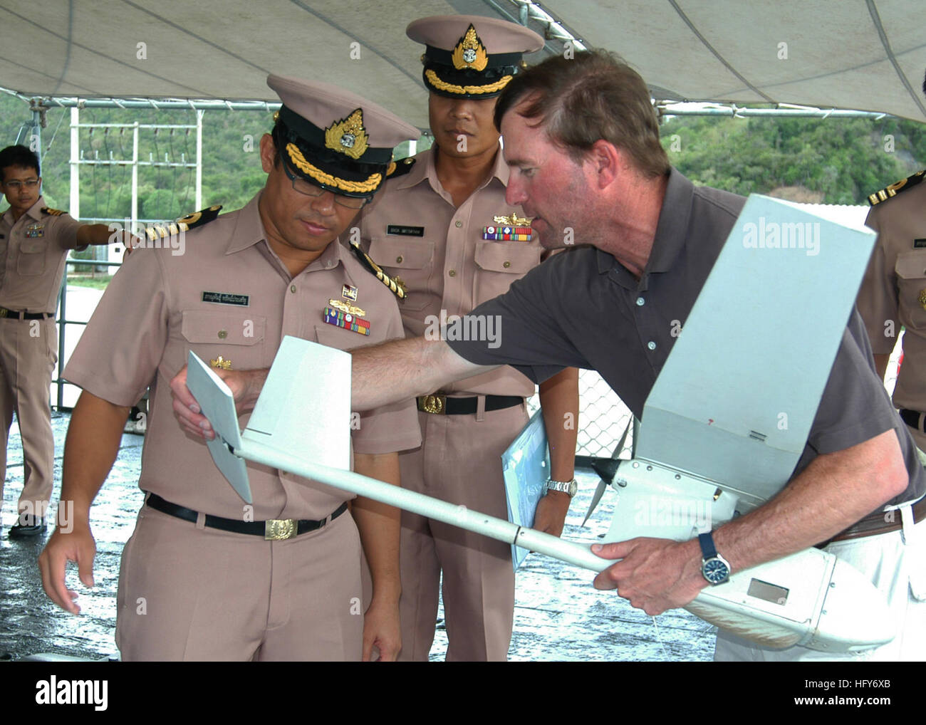 100516-N-3446M-024 SAMAESAN CAMP, Thailand (May 16, 2010) Paul Trist Jr., right, a civilian flight demonstration manager, shows Royal Thai Navy officers how to install the tail rudder on the Puma AE mini-unmanned aerial vehicle (UAV) during a demonstration of the vehicleÕs capabilities as part of Cooperation Afloat Readiness and Training (CARAT) Thailand 2010. CARAT is a series of bilateral exercises held annually in Southeast Asia to strengthen relationship and enhance force readiness. (U.S. Navy photo by Mass Communication Specialist 1st Class Kim McLendon/Released) US Navy 100516-N-3446M-02 Stock Photo