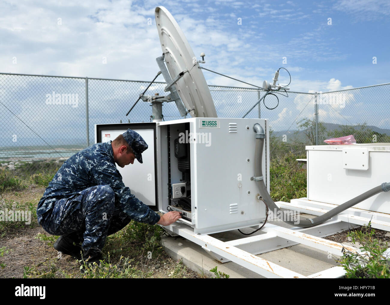 100518-N-8241M-021 GUANTANAMO BAY, Cuba (May 18, 2010) Electronics Technician 1st Class Michael Schiltz, assigned to Naval Station Guantanamo Bay (GTMO), Cuba, adjusts a modem on a U.S. Geological Survey (USGS) remote seismic station. GTMO has one of nine remote seismic stations in the Caribbean that are used to monitor seismic activity. Schiltz works with the USGS to insure the equipment is maintained and in good repair. (U.S. Navy photo by Chief Mass Communication Specialist Bill Mesta/Released) US Navy 100518-N-8241M-021 Electronics Technician 1st Class Michael Schiltz, assigned to Naval St Stock Photo