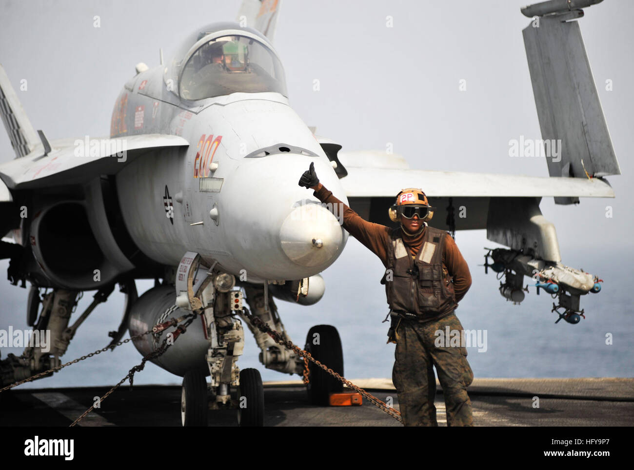 A plane captain assigned to the Checkerboards of Marine Fighter Attack Squadron 312 gives a thumbs-up to signal that the F/A-18C Hornet is ready to be moved to the catapult for take-off aboard the aircraft carrier USS Harry S. Truman. VMFA-312 is deployed as part of the Harry S. Truman Carrier Strike Group supporting maritime security operations and theater security cooperation efforts in the U.S. 5th Fleet area of responsibility. USS Harry S. Truman action DVIDS296680 Stock Photo