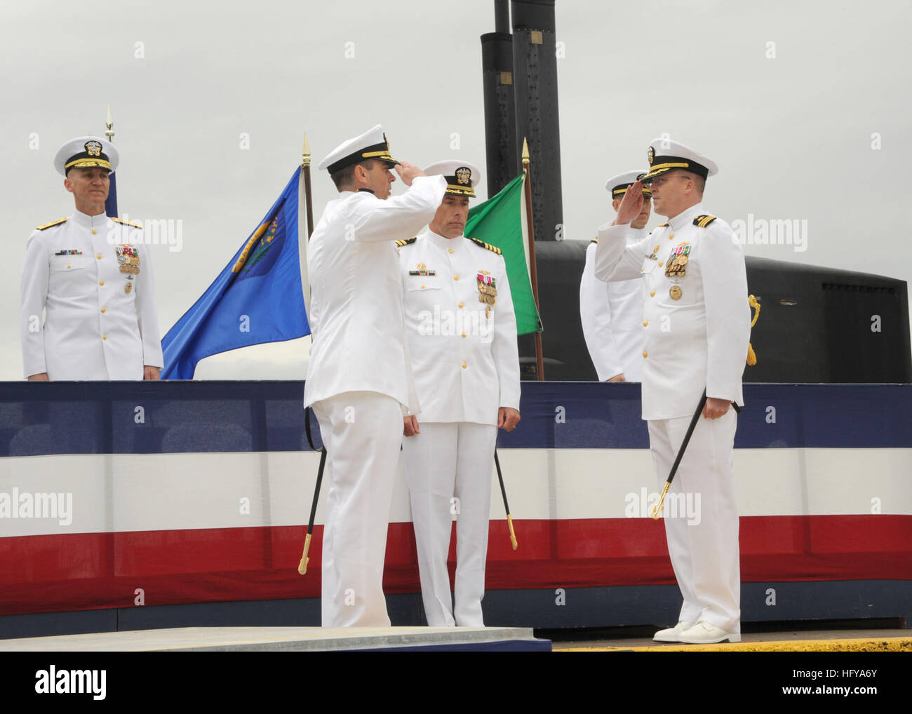 100712-N-1325N-004 SILVERDALE, Wash. (July 12, 2010) Cmdr. Peter Hudson Jr., left, and Cmdr. Alan Schrader exchange salutes during the crew split and assumption of command ceremony for the Ohio-class ballistic-missile submarine USS Nevada (SSBN 733) at Naval Base Kitsap as Capt. John Tammen, commander of Submarine Squadron 19, and Rear Adm. James Caldwell, commander of Submarine Group 9, look on. Hudson assumed command of Gold Crew from Schrader during the ceremony where the Nevada crew split into Gold Crew and Blue Crew. (U.S. Navy photo by Ray Narimatsu/Released) US Navy 100712-N-1325N-004 C Stock Photo