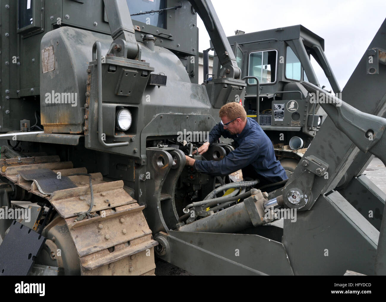 100908-N-3089C-001 PORT HUENEME, Calif. (Sept. 8, 2010)  A Naval Facilities Expeditionary Logistics Center mechanic puts the finishing touches on an armored Caterpillar D7 dozer for use building forward operating bases in Afghanistan. NFELC outfits Navy expeditionary forces with equipment necessary to perform global operational missions. (U.S. Navy photo by James P. Cencer/Released) US Navy 100908-N-3089C-001 Sailor prepares a dozer for deployment Stock Photo