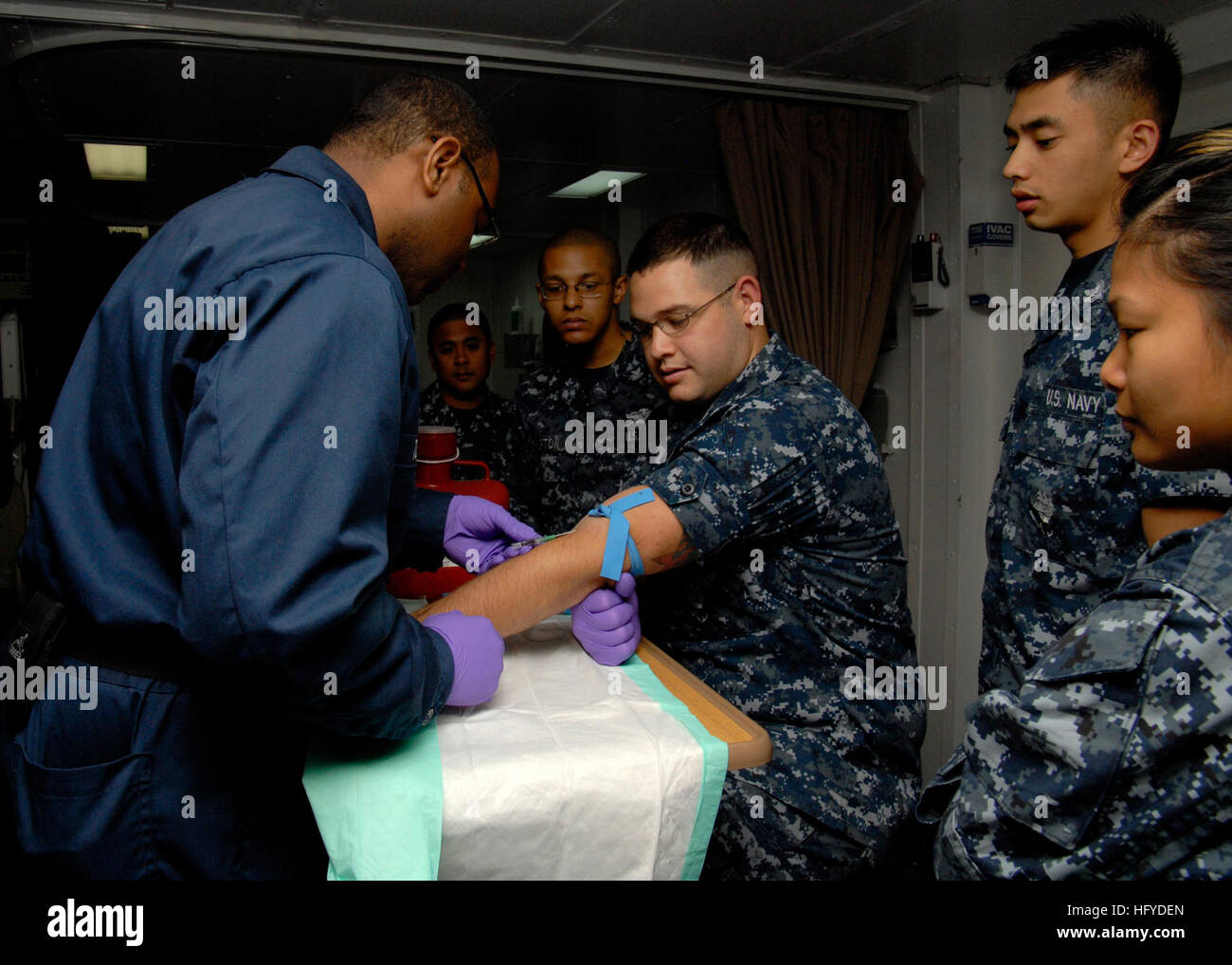 100910-N-9761H-017 SAN DIEGO (Sept. 10, 2010) Hospital Corpsman 1st Class David Toston, left, demonstrates inserting an intravenous needle into Hospital Corpsman 2nd Class Aaron Morrow's arm in the intensive care unit of the amphibious assault ship USS Boxer (LHD 4). Boxer is underway off the coast of California in preparation for an upcoming Board of Inspection and Survey (INSURV). (U.S. Navy photo by Mass Communication Specialist 2nd Class Jeff Hopkins/Released) US Navy 100910-N-9761H-017 Hospital Corpsman 1st Class David Toston, left, demonstrates inserting an intravenous needle into Hospit Stock Photo