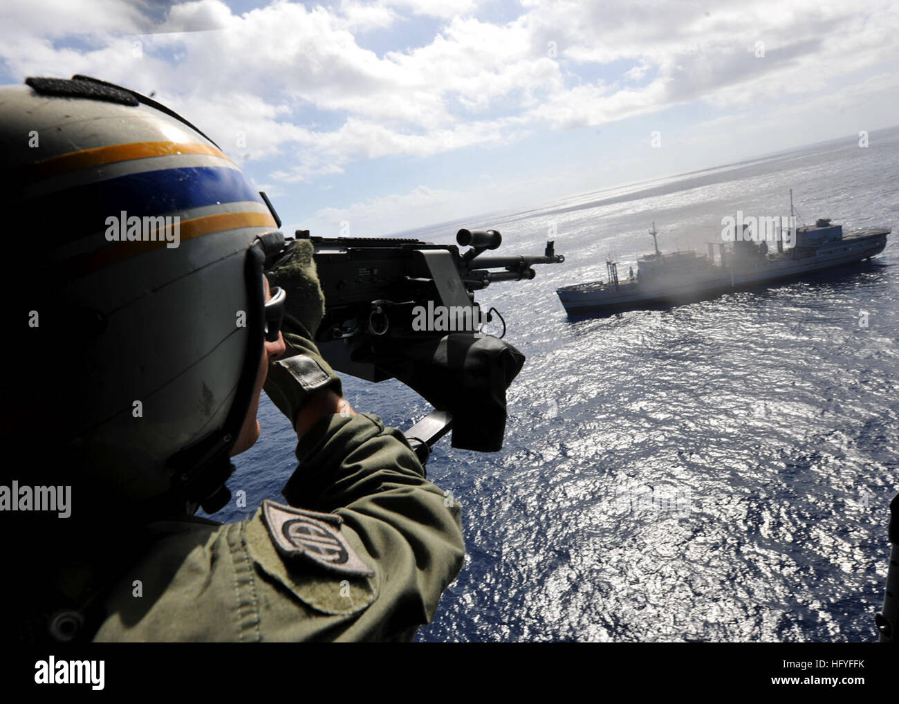 101025-N-3374C-148  ATLANTIC OCEAN (Oct. 26, 2010) Naval Air Crewmen 2nd Class William Morrison, assigned to Helicopter Maritime Strike Squadron (HSM) 70 embarked aboard the guided-missile cruiser USS Gettysburg (CG 64), fires a GAU-16 .50-caliber machine gun from an MH-60R Sea Hawk helicopter at ex-USNS Saturn during a sinking exercise. Gettysburg is part of the George H.W. Bush Carrier Strike Group and is participating in an exercise in the Atlantic Ocean. (U.S. Navy photo by Mass Communication Specialist 3rd Class Tony Curtis/Released) US Navy 101026-N-3374C-148 Naval Air Crewmen 2nd Class  Stock Photo