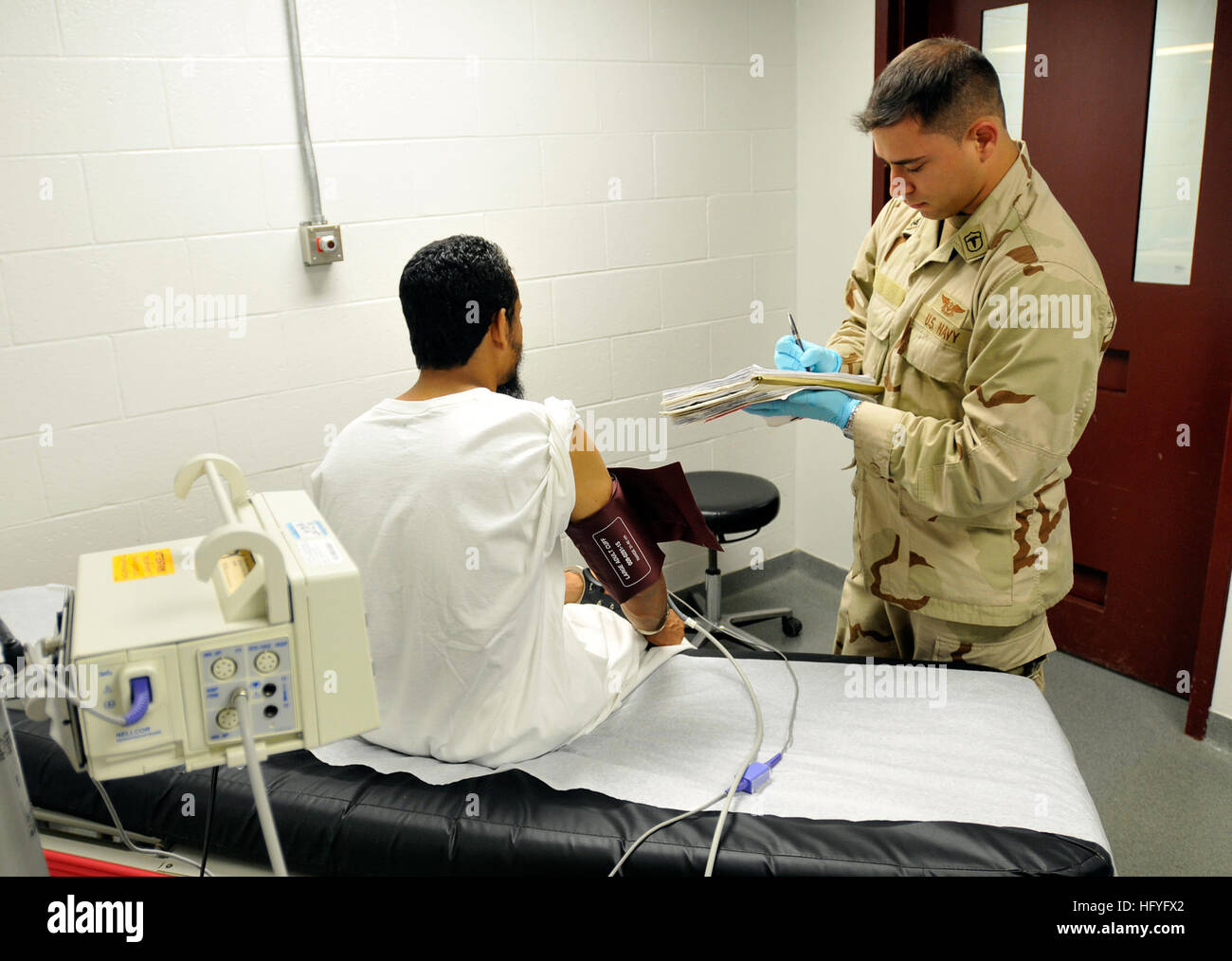 101103-N-3887D-006 GUANTANAMO BAY, Cuba (Nov. 3, 2010) Hospital Corpsman 2nd Class Miguel Mejiacontrera takes a blood pressure reading from a detainee at the Camp 6 Medical Center. Mejiacontrera is assigned to the Joint Medical Group, which provides medical care to detainees. (U.S. Navy photo by Mass Communication Specialist 2nd Class Elisha Dawkins/Released) US Navy 101103-N-3887D-006 Hospital Corpsman 2nd Class Miguel Mejiacontrera takes a blood pressure reading from a detainee at the Camp 6 Medical Ce Stock Photo