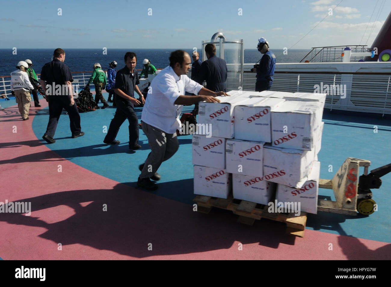 Crew-members of Carnival cruise ship C/V Splendor unload food and water sent from the aircraft carrier USS Ronald Reagan (CVN 76). Ronald Reagan was diverted from its current training maneuvers at the direction of Commander U.S. Third Fleet, and at the request of the U.S. Coast Guard, to a position south near the Carnival cruise ship C/V Splendor to facilitate the delivery of 4,500 pounds of supplies to the cruise ship. Early Monday, CV Splendor reported it was dead in the water 150 nautical miles southwest of San Diego. (Photo by: Petty Officer 3rd Class Kevin Gray) USS Ronald Reagan Action D Stock Photo