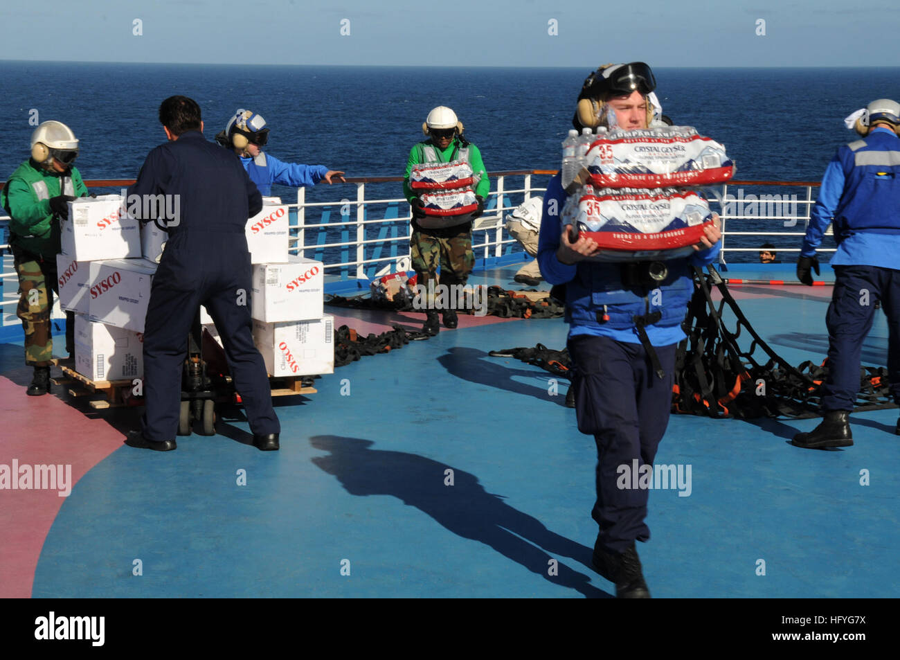 Sailors assigned to the aircraft carrier USS Ronald Reagan (CVN 76) help crew-members of Carnival cruise ship C/V Splendor unload food and water sent from Ronald Reagan. Ronald Reagan was diverted from its current training maneuvers at the direction of Commander U.S. Third Fleet, and at the request of the U.S. Coast Guard, to a position south near the Carnival cruise ship C/V Splendor to facilitate the delivery of 4,500 pounds of supplies to the cruise ship. Early Monday, CV Splendor reported it was dead in the water 150 nautical miles southwest of San Diego. (Photo by: Petty Officer 3rd Class Stock Photo