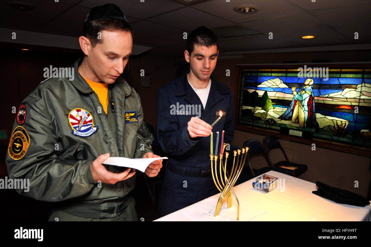 101203-N-7103C-028 WATERS WEST OF KOREAN PENINSULA (Dec. 03, 2010) Yeoman Seaman Kevin Tucker, from Quaker Town, Penn., lights the Menorah during the third day of Hanukkah while Lt. Cmdr. Ryan Hayes, from San Diego, reads a Jewish scripture in the chapel aboard the aircraft carrier USS George Washington (CVN 73).  (U.S. Navy photo by Mass Communication Specialist 3rd Class David A. Cox/Released) US Navy 101203-N-7103C-028 Yeoman Seaman Kevin Tucker, from Quaker Town, Penn., lights the Menorah during the third day of Hanukkah while Lt. Cmdr Stock Photo