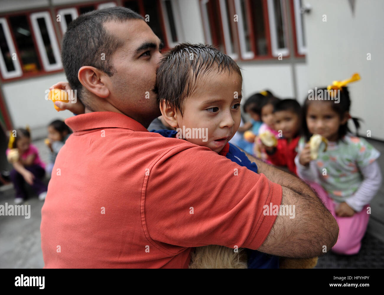 101210-N-2984R-635 EL AGUSTINO, Peru (Dec. 10, 2010) Electronics Technician 1st Class Joel Eyzaguirre, a member of Maritime Civil Affairs and Security Training Command (MCAST), hugs his godson after an arranged meeting at the Johannes Gutenberg School. Eyzaguirre is a former student at the school and is in Peru in support of Southern Partnership Station (SPS) 2011. SPS-2011 is an annual deployment of U.S. ships to the U.S. Southern Command's area of responsibility in the Caribbean and Latin America. (U.S. Navy photo by Mass Communication Specialist 2nd Class Ricardo J. Reyes/Released) US Navy  Stock Photo