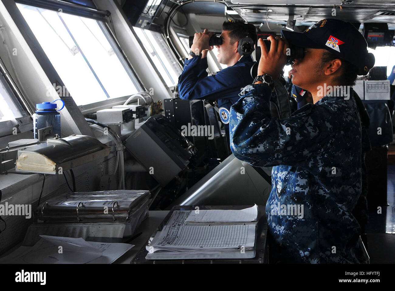 110531-N-EE987-006 ARABIAN GULF (May 31, 2011) Ensign Claudia Garcasrios, from Cordoba, Columbia, and Operations Specialist Seaman David Gomez, from San Diego, scan for surface contacts on the bridge of the aircraft carrier USS Ronald Reagan (CVN 76). Ronald Reagan and Carrier Air Wing (CVW) 14 are deployed to the U.S. 5th Fleet area of responsibility and are conducting close-air support missions as part of Operations Enduring Freedom and New Dawn. (U.S. Navy photo by Mass Communication Specialist 3rd Class Shawn J. Stewart/Released) US Navy 110531-N-EE987-006 Ensign Claudia Garcasrios and Ope Stock Photo