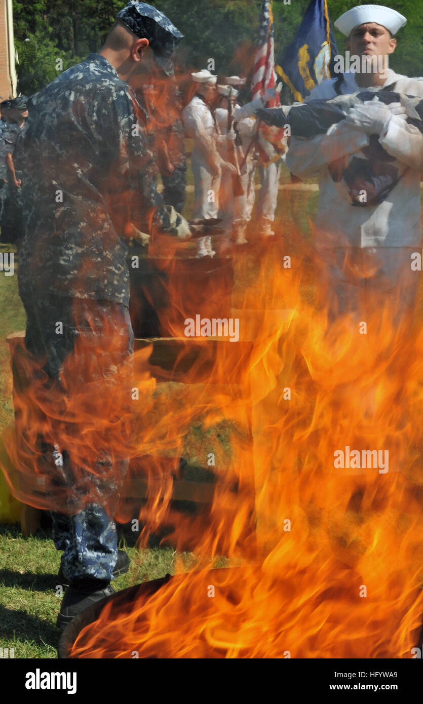 110614-N-ZZ999-041 FORT MEADE, Md. (June 14, 2011) Cryptologic Technician (Networks) 3rd Class Thomas Farquharson places a decommissioned U.S. Flag into a soaking station filled with kerosene before placing it into a fire pit during a flag decommissioning ceremony at Fort George G. Meade, Md. (U.S. Navy photo by Mass Communication Specialist 3rd Class Matthew Jordan/Released) US Navy 110614-N-ZZ999-041 Cryptologic Technician (Networks) 3rd Class Thomas Farquharson places a decommissioned U.S. Flag into a soaking station Stock Photo