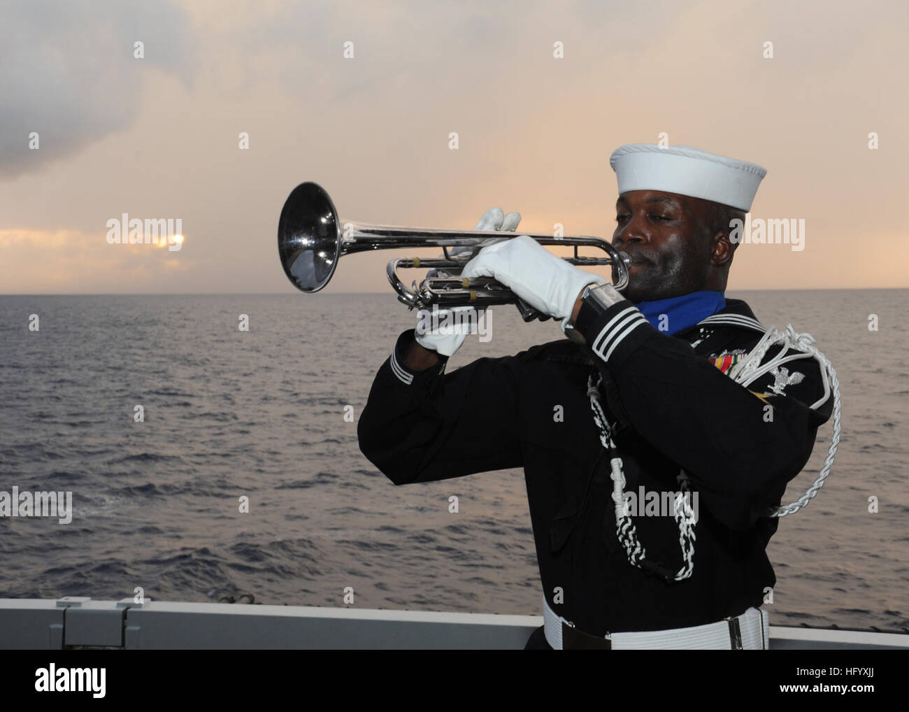 Boatswain's Mate 1st Class performs on trumpet during a burial at sea ...
