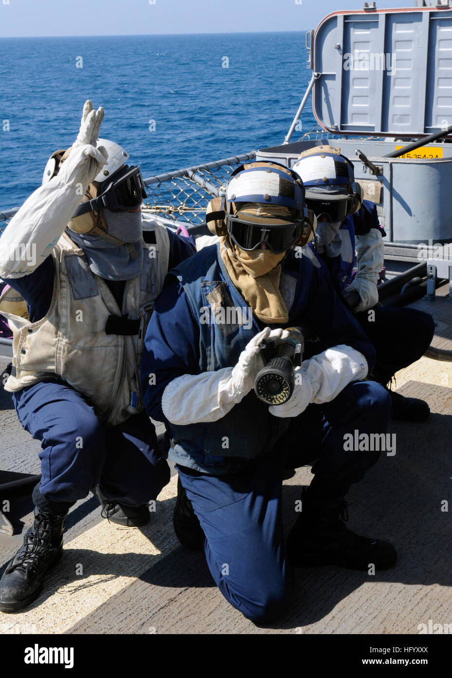 110715-N-KB052-563  TIMOR SEA (July 15, 2011) Boatswain’s Mate 3rd Class John King, leader of hose team three, communicates with the on-scene leader during a crash and salvage drill aboard the Ticonderoga-class guided-missile cruiser USS Cowpens (CG 63). Cowpens is forward deployed to Yokosuka, Japan, and is underway in the U.S. 7th Fleet area of responsibility. (U.S. Navy photo by Mass Communication Specialist 1st Class N. Ross Taylor/Released) US Navy 110715-N-KB052-563 Boatswain's Mate 3rd Class John King, leader of hose team three, communicates with the on-scene leader during a crash a Stock Photo