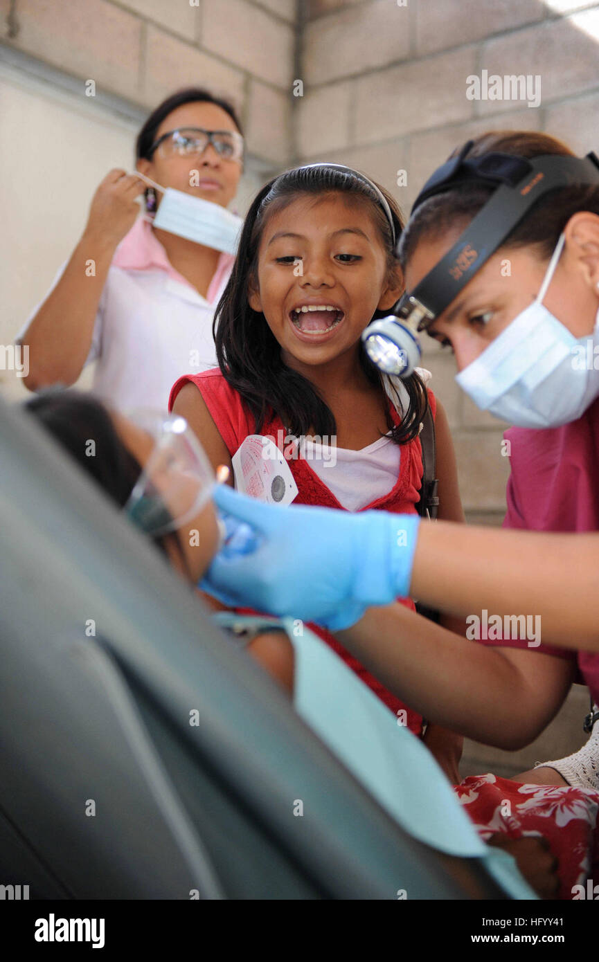 110719-F-ET173-051 ACAJUTLA, El Salvador (July 19, 2011) A girl shows her sister how to 'open wide' as Peruvian navy Lt. Mariann Rossi pulls her tooth during a Continuing Promise 2011 community service medical event at the Polideportivo medical site. Continuing Promise is a five-month humanitarian assistance mission to the Caribbean, Central and South America. (U.S. Air Force photo by Staff Sgt. Alesia Goosic/Released) US Navy 110719-F-ET173-051 A girl shows her sister how to Stock Photo