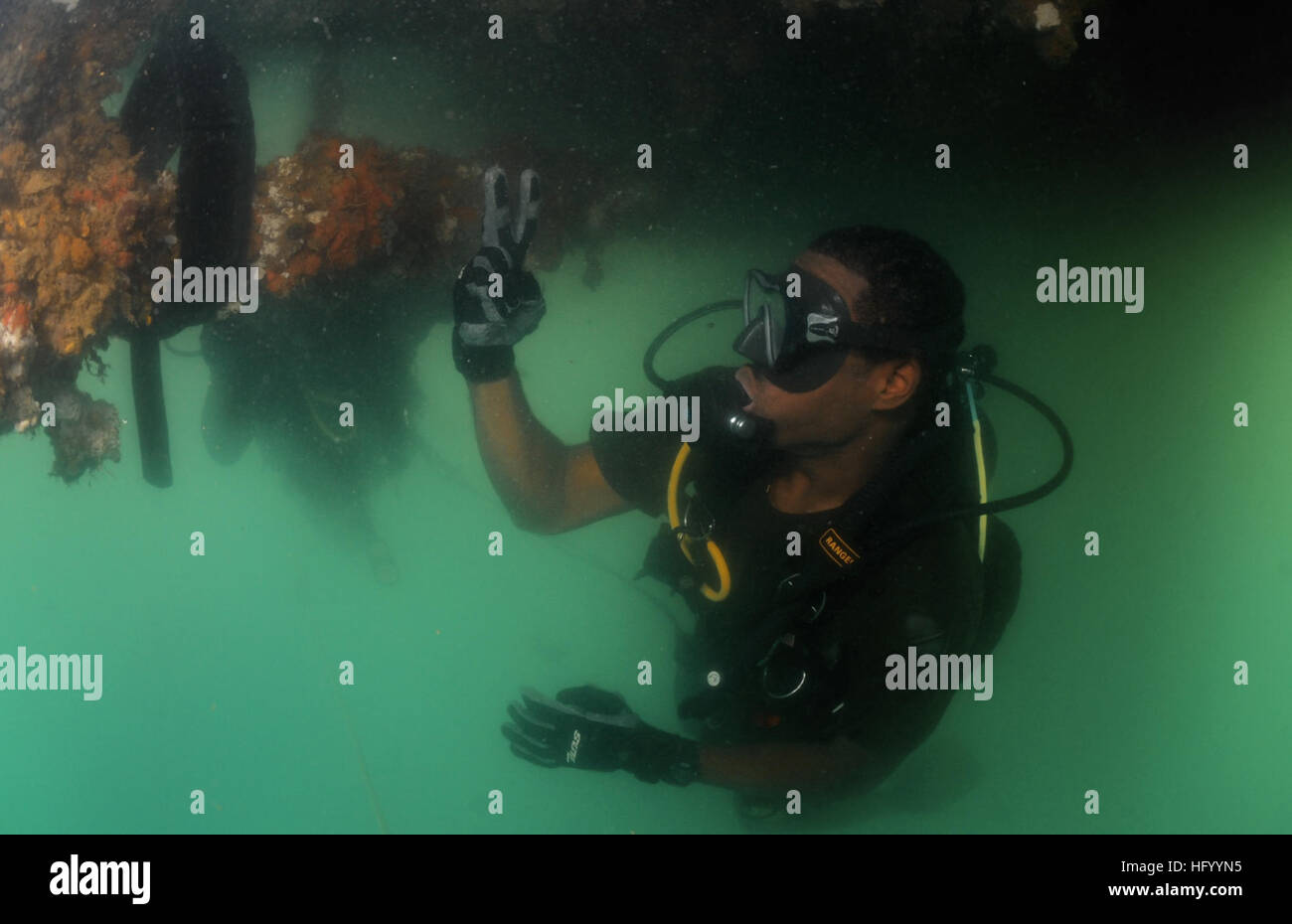 110729-N-XD935-203 PORT ROYAL, Jamaica (July 29, 2011) Royal Bahamas Defense Force diver Able Body Seaman Raynaldo Farquharson signals that he has found an inert training mine while conducting a security sweep on the bottom of a Jamaican Coast Guard Vessel during joint diving operations with Mobile Diving and Salvage Unit (MDSU) 2. MDSU 2 is participating in Navy Diver-Southern Partnership Station, a multinational partnership engagement designed to increase interoperability and partner nation capability through diving operations. (U.S. Navy photo by Mass Communication Specialist 1st Class Jaym Stock Photo