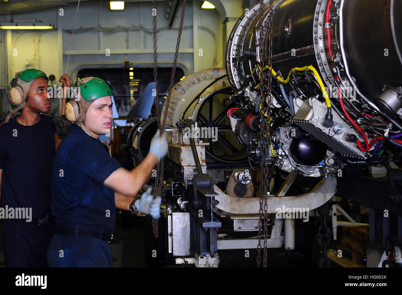 Aviation Machinist’s Mate hoists an F404 Legacy Hornet engine in the ...