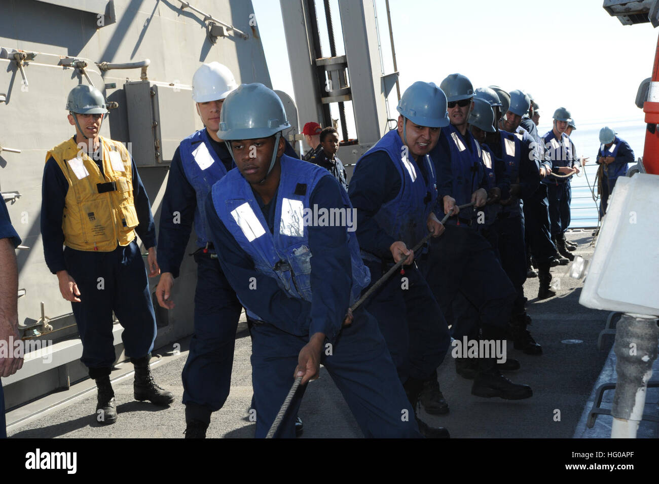 Line handlers maintain tension on a line aboard the guided-missile ...