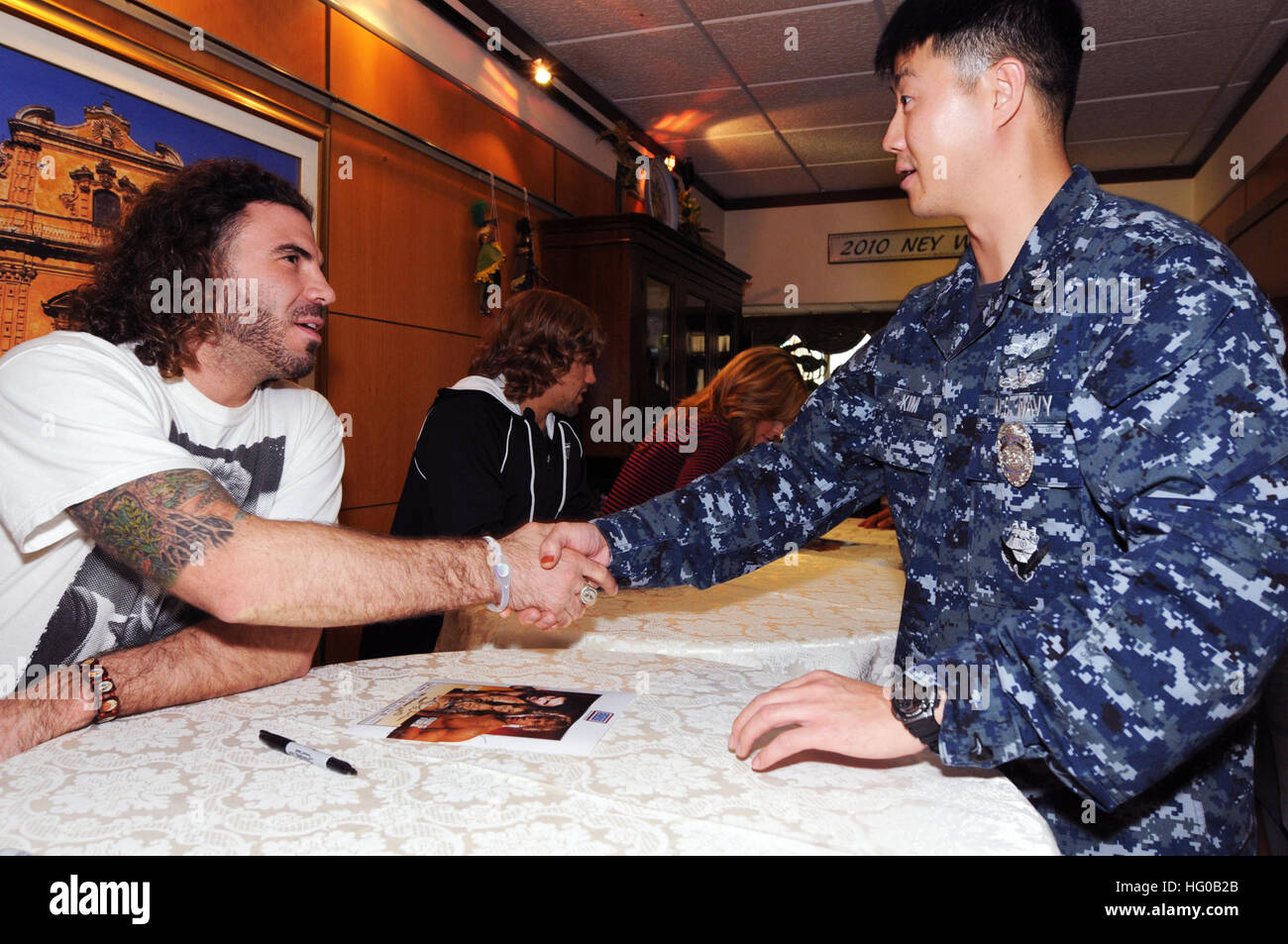 111214-N-RN782-021 SIGONELLA, Sicily (Dec. 14, 2011) Clay 'The Carpenter' Guida, Xtreme Kage Kombat Lightweight champion, shakes hands with a Sailor at Naval Air Station Sigonella in the base galley. Guida was on a nine-day tour, sponsored by Armed Forces Entertainment, to visit with service members and their family members. (U.S. Navy photo by Mass Communication Specialist Seaman Apprentice Brian Glunt/Released) US Navy 111214-N-RN782-021 Clay Stock Photo