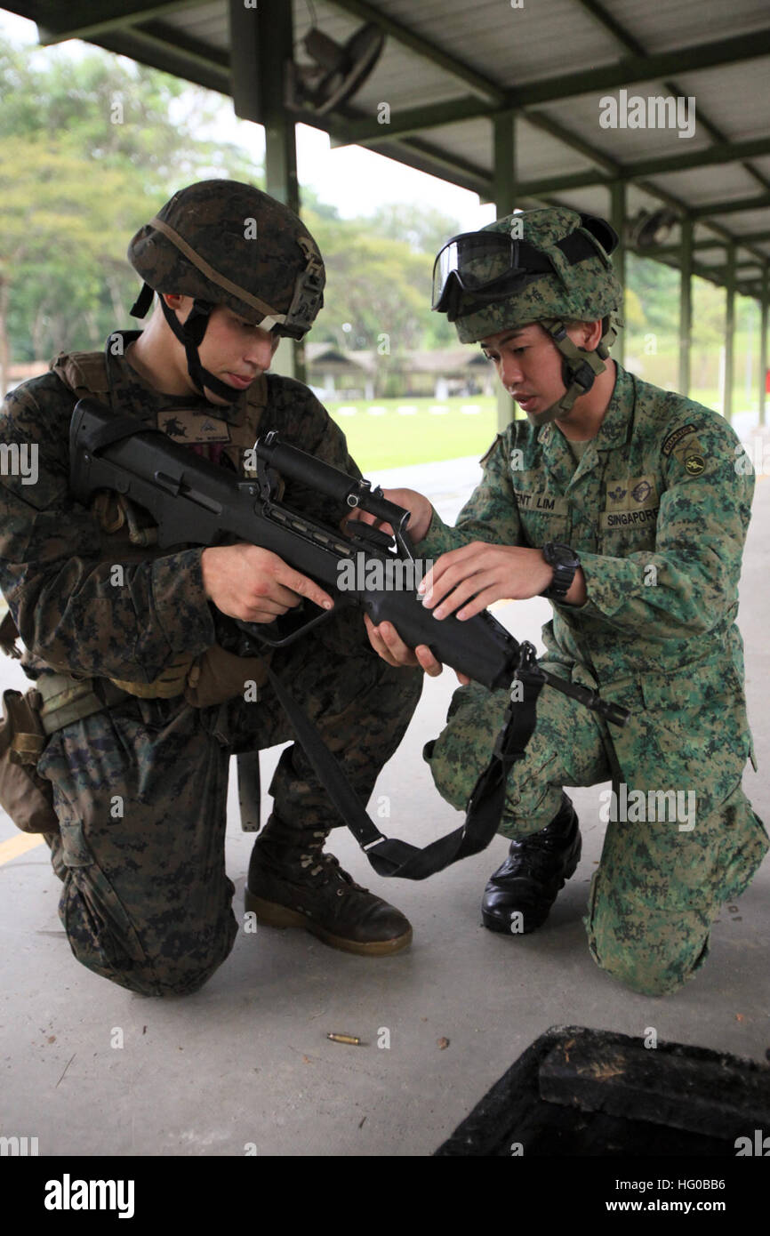 111217-M-YP701-044 MURAI, Singapore (Dec. 17, 2011) Lance Cpl. Kevin L. Brown, left, from Jarrell, Texas, assigned to Weapons Company, Battalion Landing Team 3/1, the ground element of the 11th Marine Expeditionary Unit (11th MEU), and a Singapore armed forces service member interact. The Camp Pendleton, Calif., based unit deployed from San Diego Nov. 14 aboard the amphibious assault ship USS Makin Island (LHD 8), the amphibious transport dock ship USS New Orleans (LPD 18) and the amphibious dock landing ship USS Pearl Harbor (LSD 52) and arrived in Singapore Dec. 12 as part of a scheduled dep Stock Photo