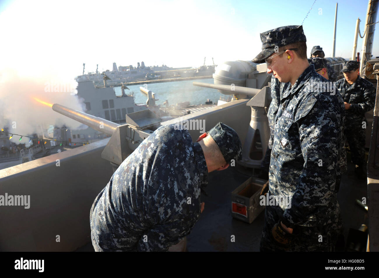 111219-N-AU622-059  NORFOLK (Dec. 19, 2011) Airman Apprentice Cody Lichvar observes as Gunner's Mate 3rd Class Phillip Furlong fires a 17-gun salute for Admiral John C. Harvey, Jr., commander of United States fleet forces command, aboard the aircraft carrier USS Dwight D. Eisenhower (CVN 69). Eisenhower is moored at Naval Station Station Norfolk. (U.S. Navy photo by Mass Communication Specialist 3rd Class Nathan Parde/Released) US Navy 111219-N-AU622-059 Airman Apprentice Cody Lichvar observes as Gunner's Mate 3rd Class Phillip Furlong fires a 17-gun salute for Admiral Joh Stock Photo