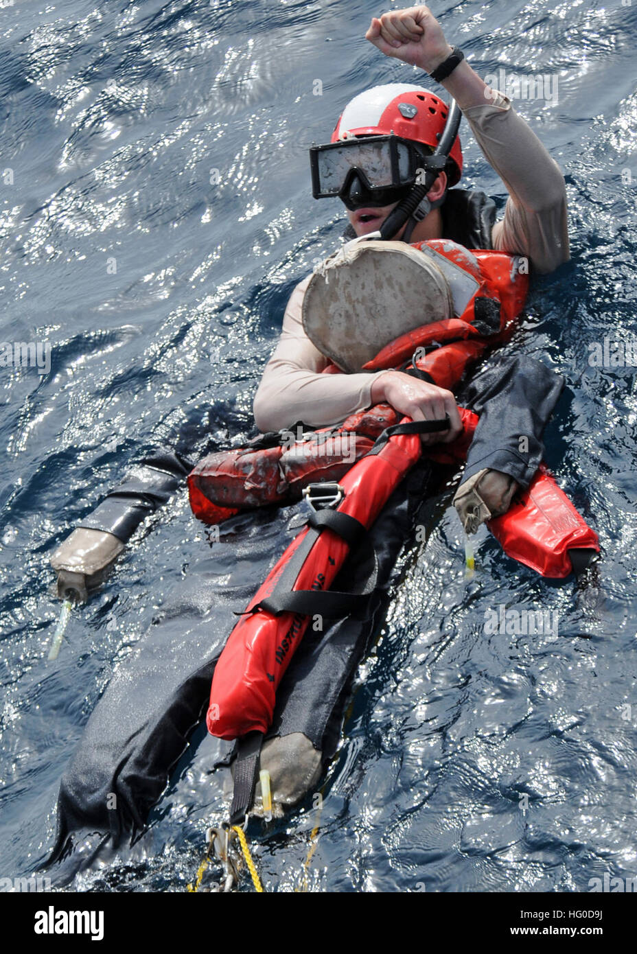 120124-N-ZF681-155 ARABIAN SEA (Jan. 24, 2012) Search and rescue swimmer Ensign Gregory Reichel, assigned to the guided-missile destroyer USS Halsey (DDG 97), signals to the boat deck petty officer in charge that the training dummy is secure during a man overboard recovery drill. Halsey is on a deployment to the western Pacific region. (U.S. Navy photo by Mass Communication Specialist 3rd Class Christopher Farrington/Released) US Navy 120124-N-ZF681-155 Search and rescue swimmer Ensign Gregory Reichel, assigned to the guided-missile destroyer USS Halsey (DDG 97), signals Stock Photo