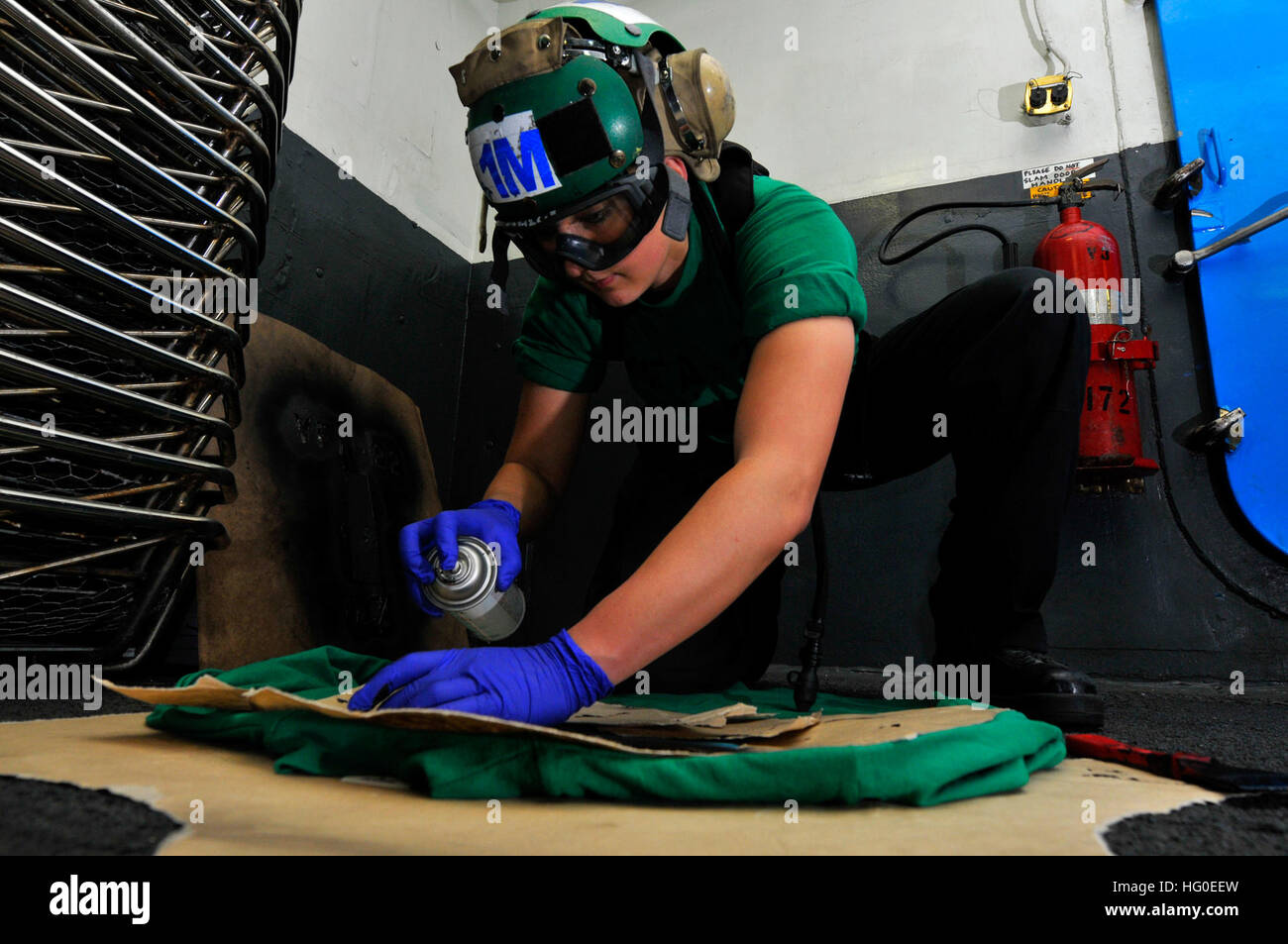 120209-N-ZI635-026  ARABIAN SEA (Feb. 9, 2012) Aviation Structural Mechanic Airman Caitlin Vancourt, assigned to Strike Fighter Squadron (VFA) 22, stencils flight deck jerseys in the hangar bay aboard the Nimitz-class aircraft carrier USS Carl Vinson (CVN 70). Carl Vinson and Carrier Air Wing (CVW) 17 are deployed to the U.S. 5th Fleet area of responsibility. (U.S. Navy photo by Mass Communication Specialist Seaman George M. Bell/Released) US Navy 120209-N-ZI635-026 Aviation Structural Mechanic Airman Caitlin Vancourt, assigned to Strike Fighter Squadron (VFA) 22, stencils flight deck Stock Photo