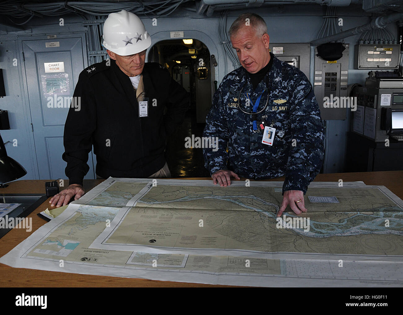 Capt. Pete Hildreth, commanding officer of the submarine tender USS Frank Cable (AS 40), shows Rear Adm. James Caldwell Jr., Commander, Submarine Force, U.S. Pacific Fleet, the navigation charts used to travel down the Columbia River. Frank Cable is temporarily relieved from conducting maintenance of submarines and service vessels deployed in the U.S. 7th Fleet area of responsibility by the submarine tender USS Emory S. Land (AS 39) and is currently in Portland for a regular overhaul and dry-docking. USS Frank Cable 120309-N-CO162-021 Stock Photo