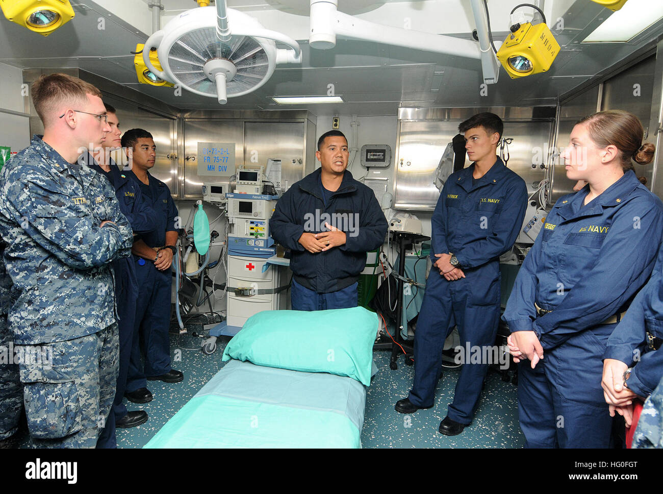 Hospital Corpsman 1st Class Augustine Torrez explains the role of the operating room aboard the amphibious assault ship USS Makin Island (LHD 8) to midshipmen from the U.S. Naval Academy. The group toured the ship's medical department during their 2012 professional training of midshipmen (PROTRAMID) program. Fifty-four midshipmen got underway with the crew of Makin Island to learn about naval surface operations and experience life at sea. (U.S. Navy photo by Mass Communication Specialist 1st Class David McKee) USS Makin Island Maiden deployment 120725-N-FH966-065 Stock Photo