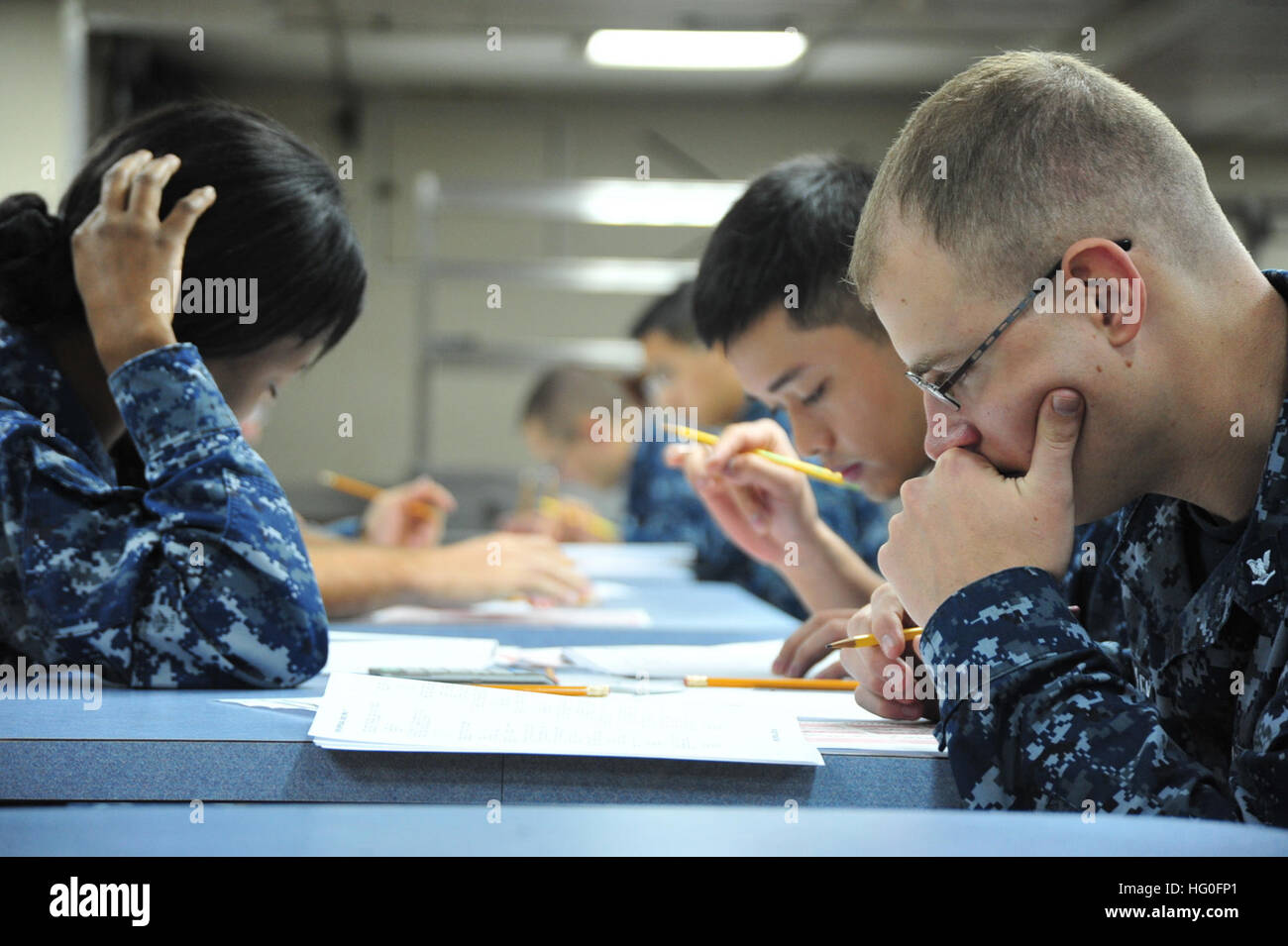 Sailors take the second class petty officer advancement exam aboard U.S