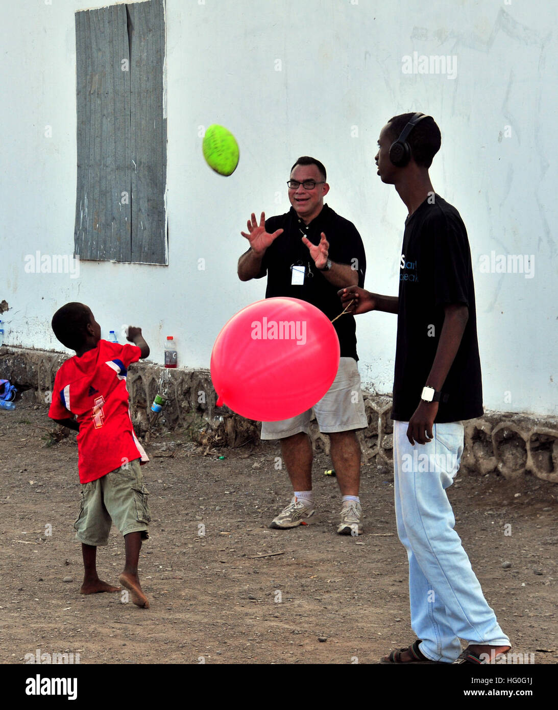 Navy Chaplain Lt. Tom Bingol, assigned to guided-missile frigate USS Halyburton (FFG 40), throws a football with a local boy during a community relations (COMREL) event. Halyburton is deployed with Commander, Task Group (CTG) 508, promoting maritime security operations and theater security cooperation efforts in the U.S. 5th Fleet area of responsibility. (U.S. Navy photo by Mass Communication Specialist 2nd Class Scott Raegen/Released) USS Halyburton (FFG 40) 121105-N-YG591-161 Stock Photo