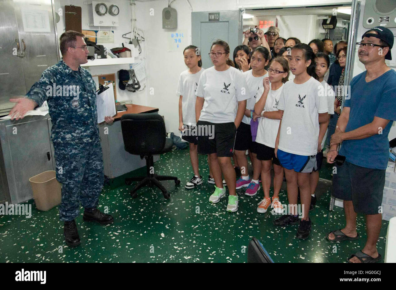 Hospital Corpsman 1st Class Clayton Smith explains the capabilities of the medical ward to students from Grace Christian Academy during a tour of the submarine tender USS Frank Cable (AS 40). Frank Cable conducts maintenance and support of submarine and surface vessels deployed in the U.S. 7th Fleet area of responsibility. (U.S. Navy photo by Mass Communication Specialist 1st Class Jason C. Swink) USS Frank Cable tour 130114-N-CB621-219 Stock Photo