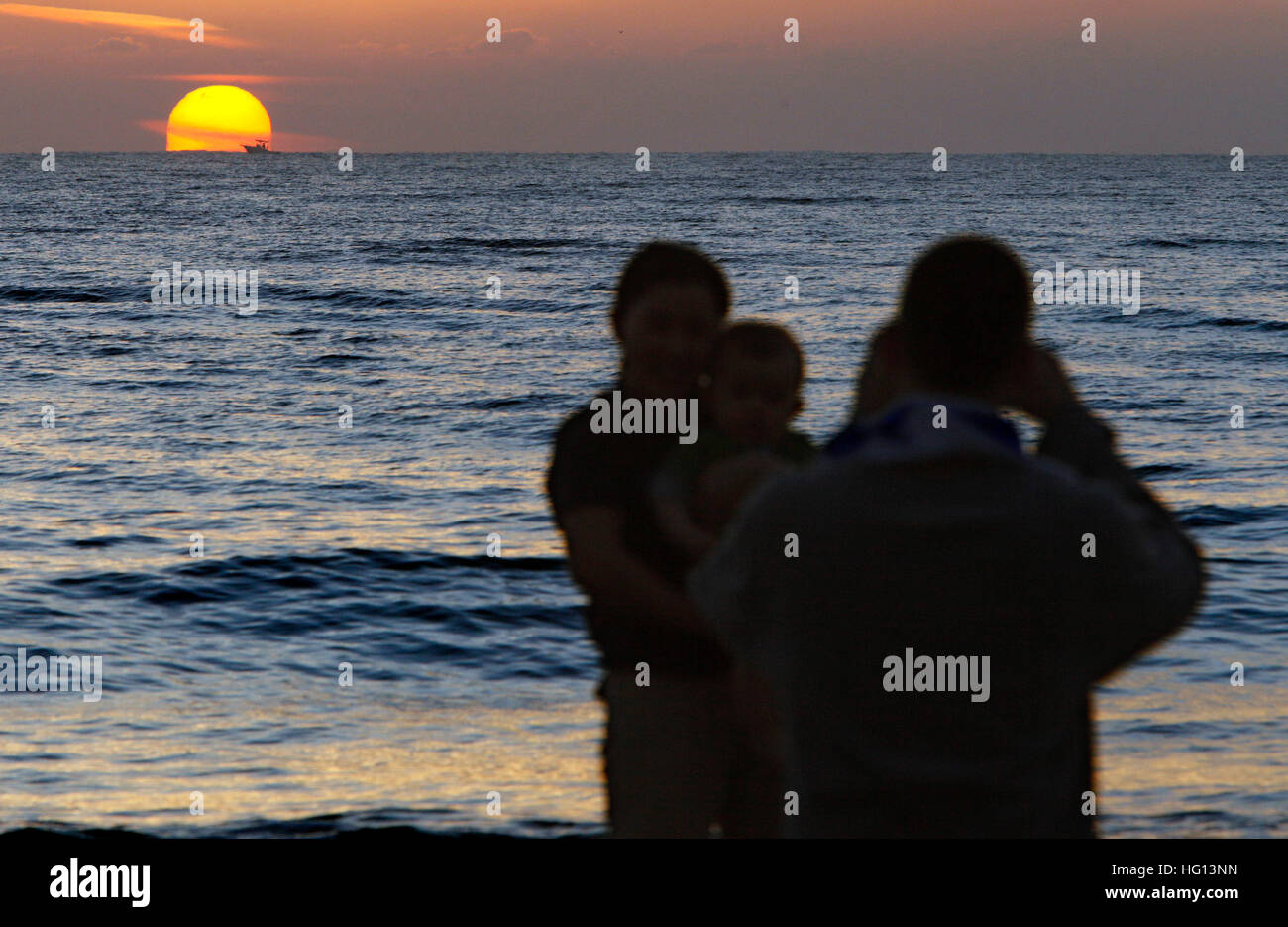 Florida, USA. 3rd Jan, 2017. 1010110 (Lannis Waters/The Palm Beach Post) LAKE WORTH - Lee Tanton (cq) takes a photo of his wife Jae Eun Kim (cq) and their son, Richard Kim Tanton (cq) at Lake Worth Municipal Beach as the sun rises New Years Day. It's Richard's first New Year; he was born January 2 last year. Jae says it is a tradition in her culture to greet the first sunrise of the year and make wishes for the new year, and she wants to continue the tradition here. © Lannis Waters/The Palm Beach Post/ZUMA Wire/Alamy Live News Stock Photo
