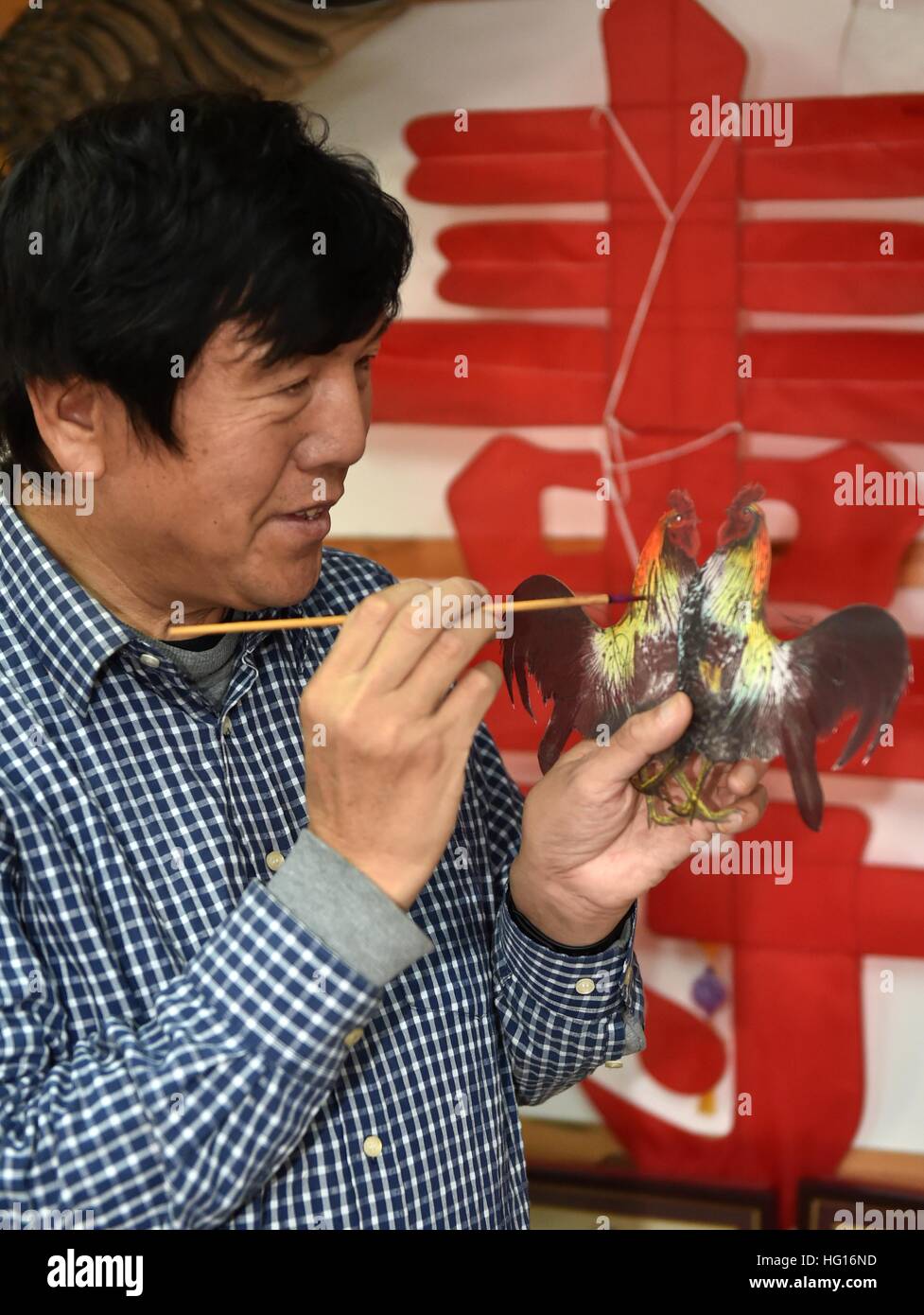 Tianjin, China. 4th Jan, 2017. Wei Guoqiu, the 4th generation of Kite Wei craftsman, makes a rooster-shaped kite to celebrate upcoming Chinese lunar new year at his studio in Tianjin, north China, Jan. 4, 2017. Kite making is a traditional Chinese folk handicraft, and Tianjin Kite Wei is famous for its development on some 200 kites with many new designs. © Lian Yi/Xinhua/Alamy Live News Stock Photo