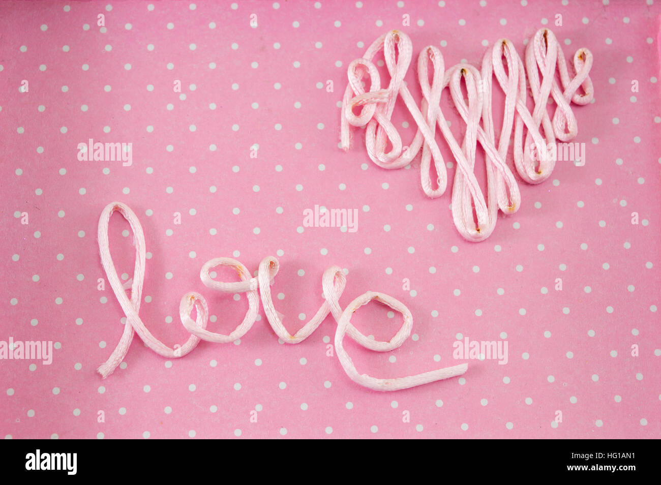 Word love made out of thread on pink background Stock Photo - Alamy