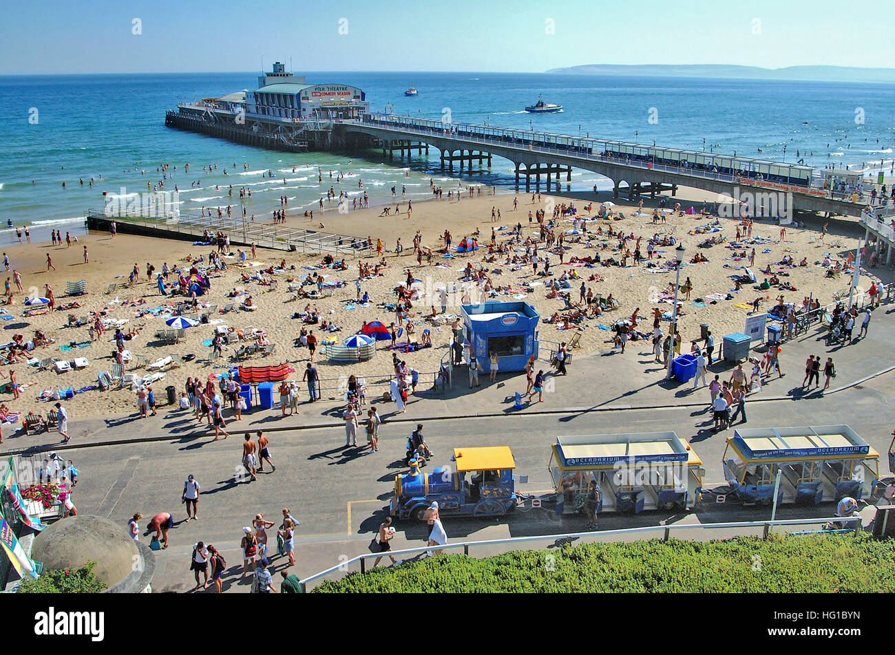 High view of Bournemouth's promenade, land train, seafront, and pier in the background. Stock Photo