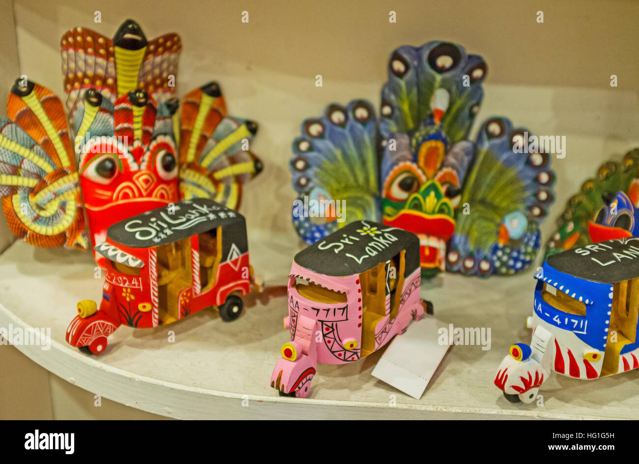 The small wooden tuk tuks among masks and other souvenirs in tourist store Stock Photo