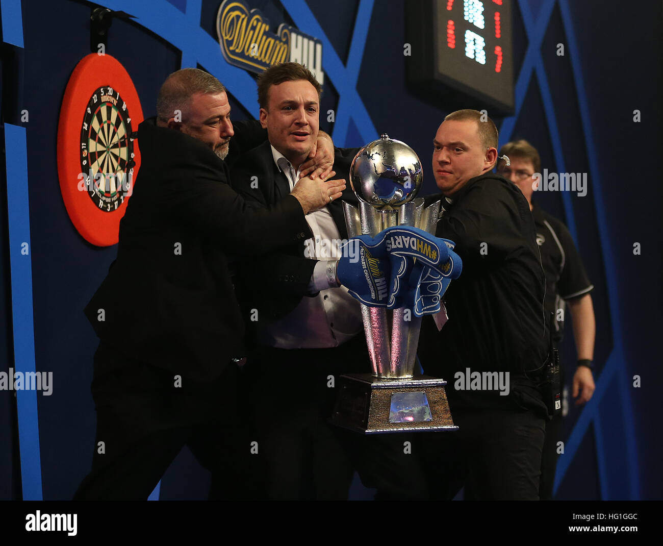 A spectators invades the oche and lift up the Sid Waddell trophy as