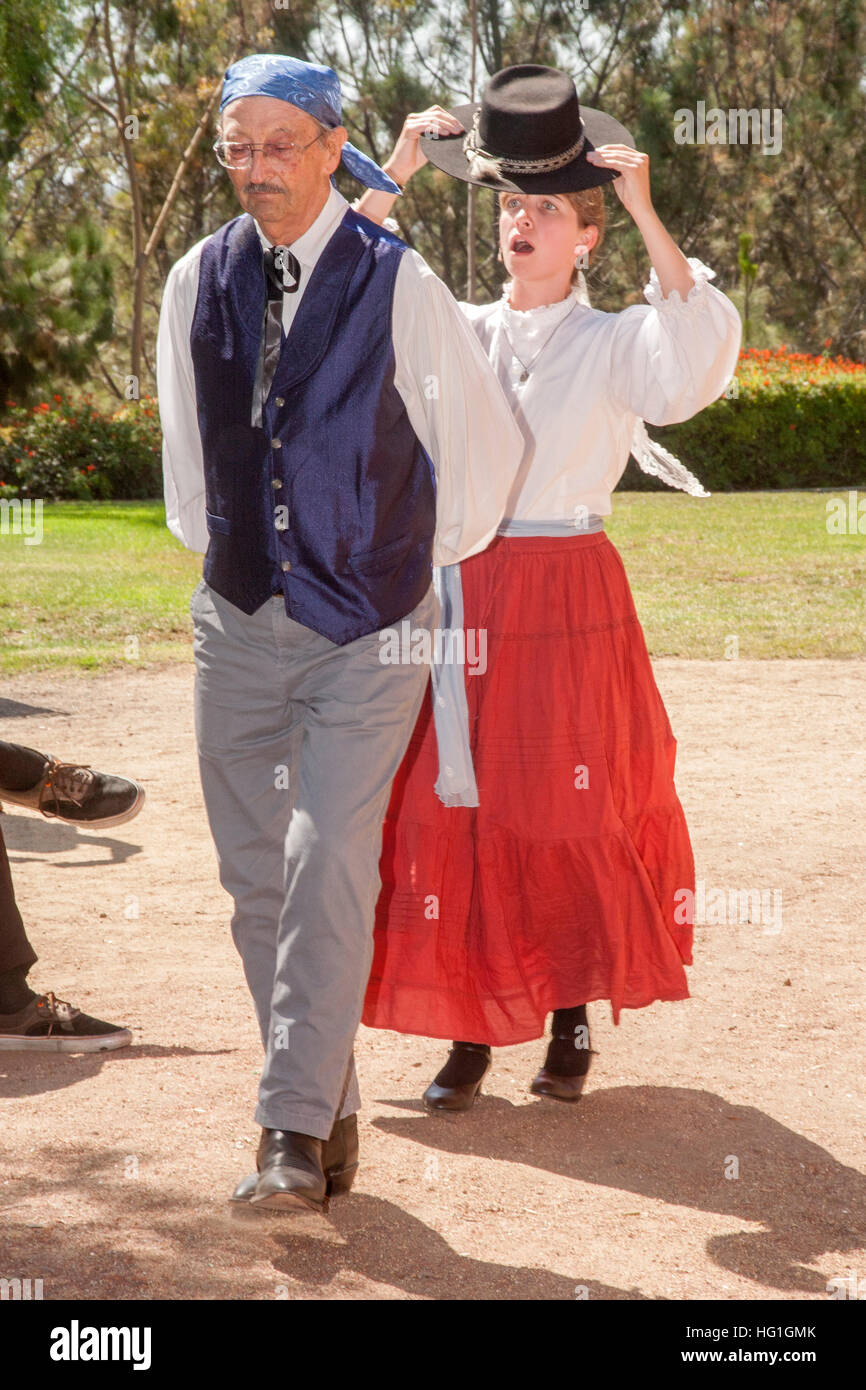 Dressed as old time Spanish Californians, a dance teacher and student perform a historical Spanish colonial dance at an 'Early California Days' festival in a park in Costa Mesa, CA. Stock Photo