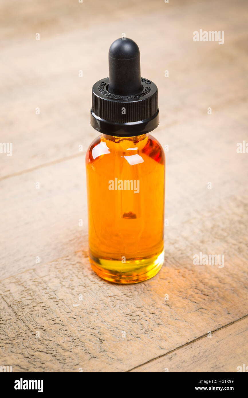 Vaping ecig juice bottles over wood background. EJuice in bottle with