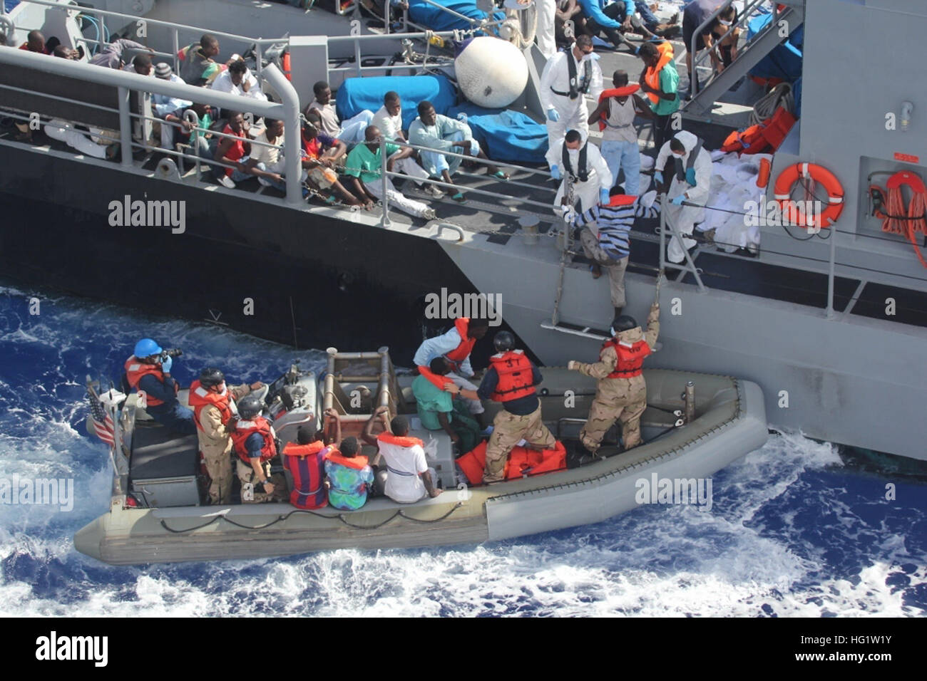 Distressed persons are transferred from the amphibious transport dock ship USS San Antonio (LPD 17) to armed forces of Malta offshore patrol vessel P52. San Antonio provided food, water, medical attention, and temporary shelter to the rescued. San Antonio rescued 128 men adrift in an inflatable raft after responding to a call by the Maltese government. (U.S. Navy photo/Released) USS San Antonio assists in rescue 131017-N-ZZ999-007 Stock Photo