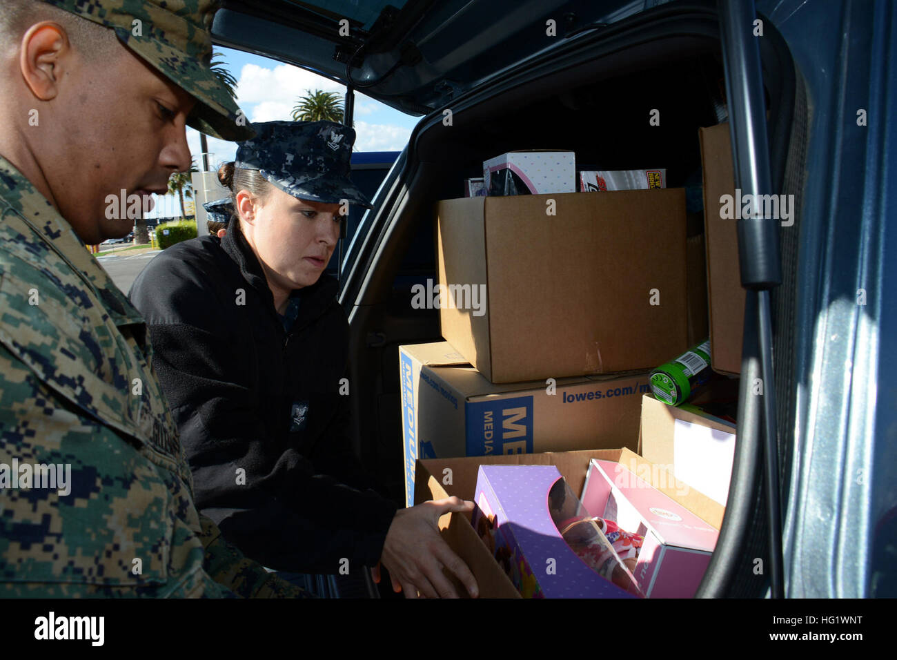 Gunnery Sgt. Edwin Guzman (left) and Fire Controlman 2nd Class Aimee Clemens load toy donations from Novartis Pharmaceuticals Corporation for the amphibious transport dock ship USS Green Bay (LPD 20) Children’s Christmas Party. Green Bay is conducting a regularly scheduled dry dock period. (U.S. Navy photo by Mass Communication Specialist 1st Class Elizabeth Merriam/Released) USS Green Bay activity 131205-N-BB534-147 Stock Photo