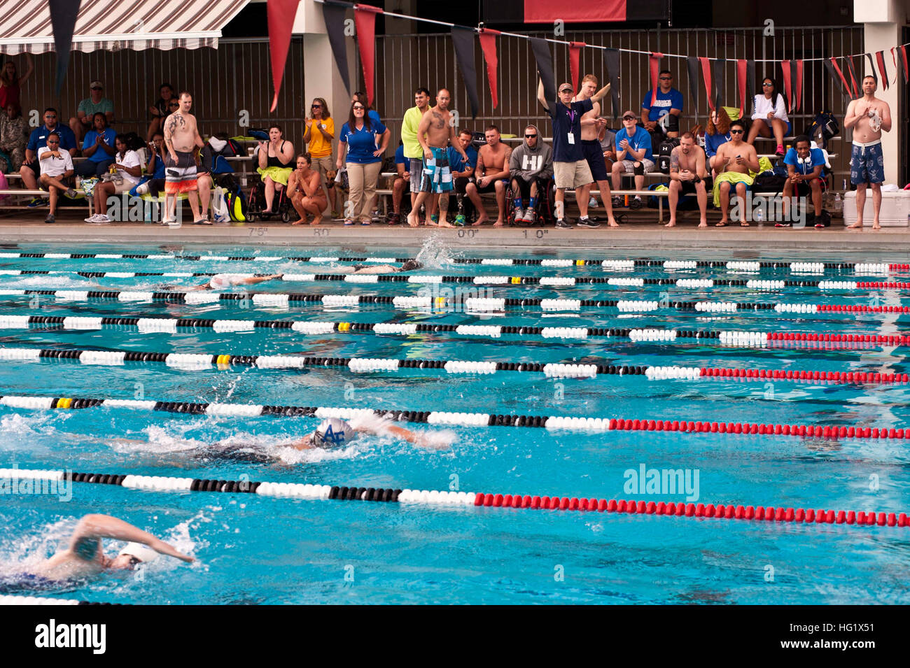 Spectators cheer on service members swimming in the 50m women's