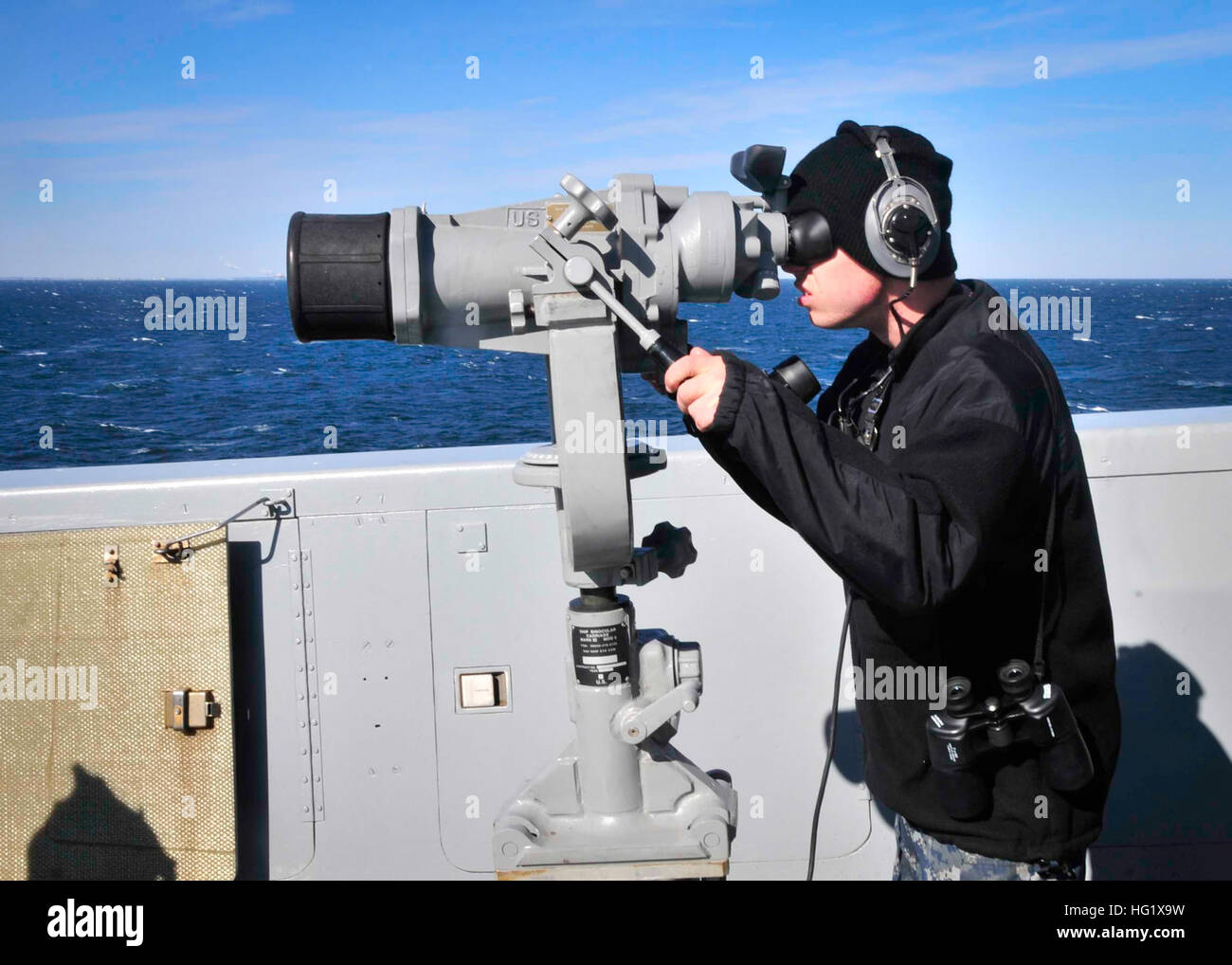 140124-N-YO707-013 Atlantic Ocean. (Jan. 24, 2014) Seaman Robert Tracy looks through the big eyes for surface contact while standing as port lookout aboard amphibious transport dock ship USS New York (LPD 21). (U.S. Navy photo by: Mass Communication Specialist 2nd Class Cyrus Roson/ Released) USS New York operations 140124-N-YO707-013 Stock Photo