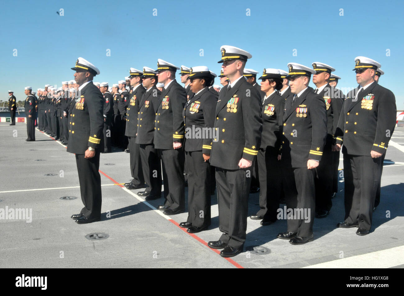 Sailors aboard the amphibious transport dock ship USS New York (LPD 21) participate in a change of command ceremony. New York recently shifted homeport to Naval Station Mayport, Fla., as part of a larger move of an amphibious ready group homeport change in support of strategic maritime dispersal. (U.S. Navy photo by Mass Communication Specialist 3rd class Angus Beckles/Released) USS New York change of command ceremony 140214-N-GC472-210 Stock Photo