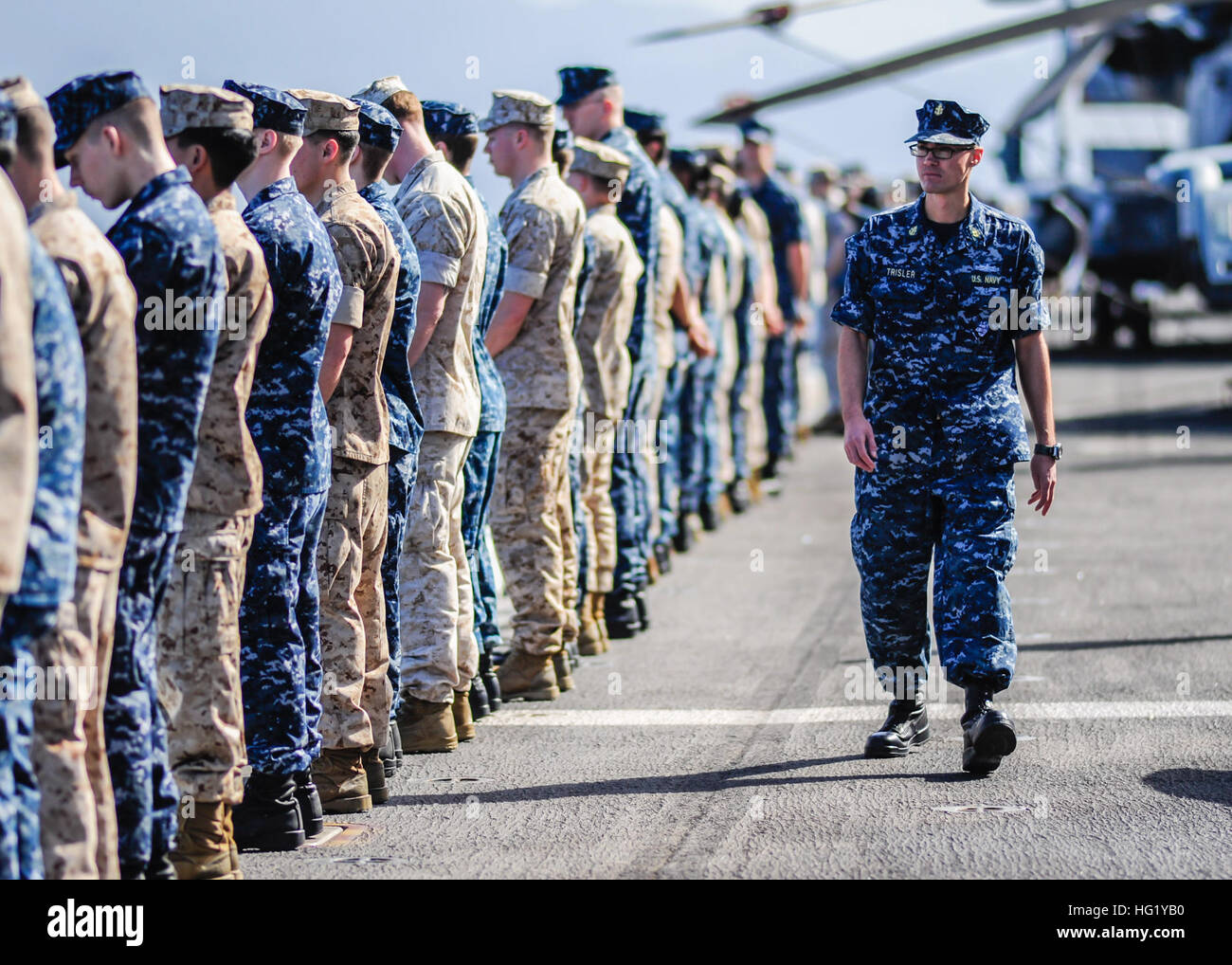Chief Yeoman Mike Trisler supervises as Sailors and Marines aboard to the amphibious assault ship USS Boxer (LHD 4) man the rails as they arrive in Pearl Harbor, Hawaii. Boxer is the flagship for the Boxer Amphibious Ready Group and, with the embarked 13th Marine Expeditionary Unit, is currently returning to its homeport of San Diego from an eight-month deployment to the western Pacific and the U.S. Central Command areas of responsibility. (U.S. Navy photo by Mass Communication Specialist Seaman Veronica Mammina/Released) USS Boxer operations 140415-N-GM561-082 Stock Photo
