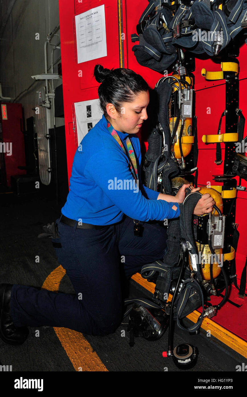 140527-N-WO404-235 PACIFIC OCEAN (May 27, 2014) – Aviation Boatswain’s Mate (Handling) Airman Sarah Atiyyat, from Edison City, N.J., puts a Self Contained Breathing Apparatus (SCBA) into an SCBA locker aboard the aircraft carrier USS Ronald Reagan (CVN 76). Ronald Reagan is currently underway conducting carrier qualifications. (U.S. Navy photo by Mass Communication Specialist Seaman Jonathan Nelson /Released) USS Ronald Reagan operations 140527-N-WO404-235 Stock Photo